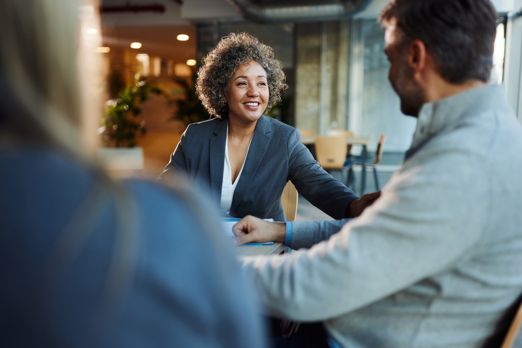 Real estate agent meeting with her clients in the lobby of a building.