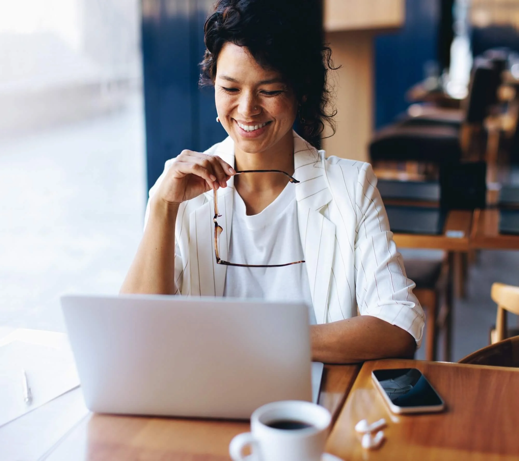 Businesswoman working on a laptop in a cafe.