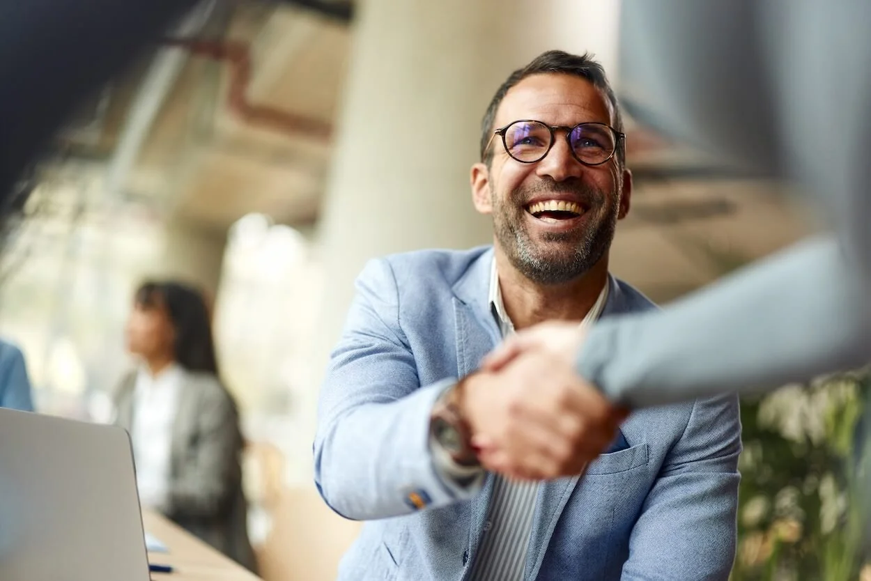 Happy businessman shaking hands with a client.