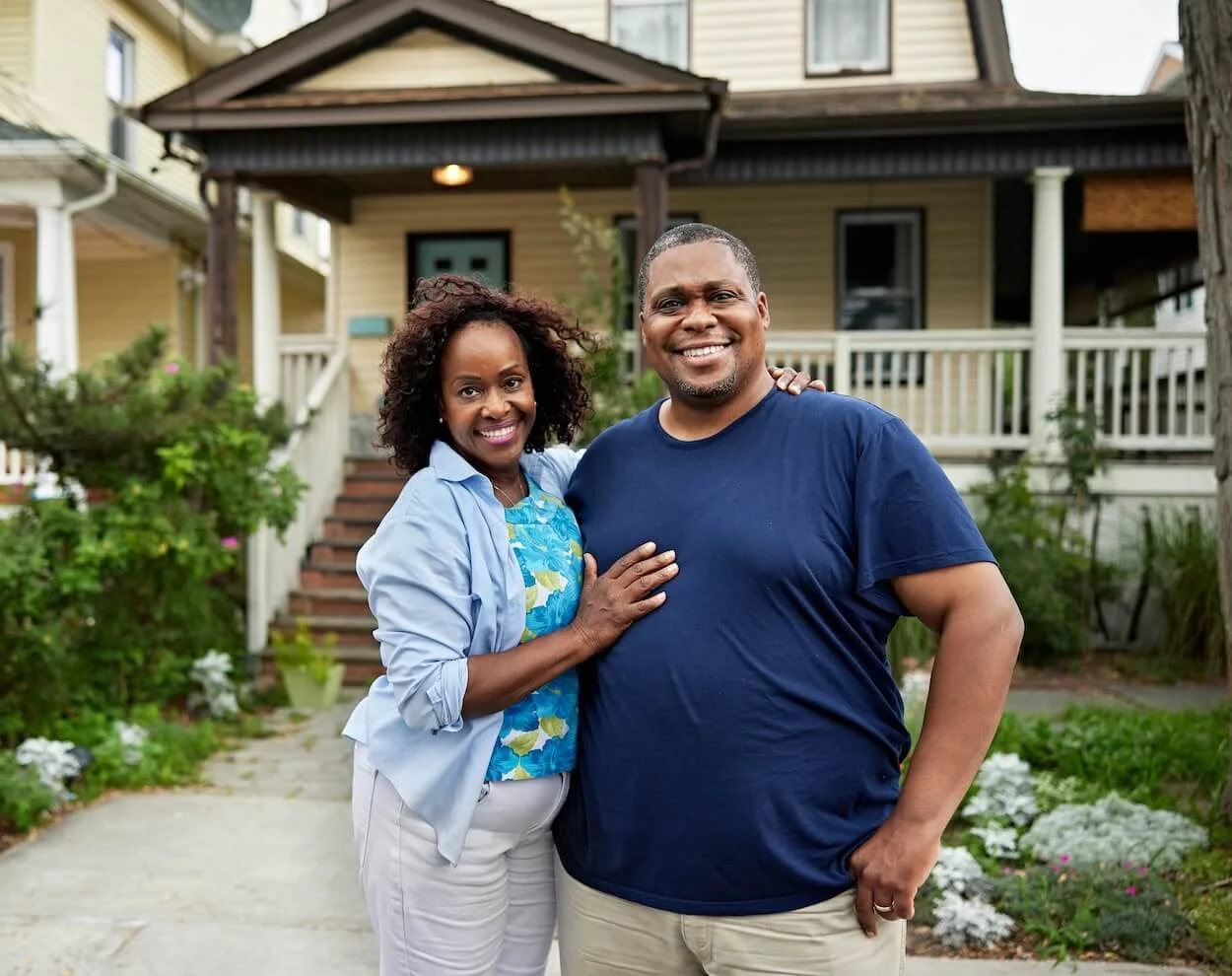 Happy family standing outside their new home.