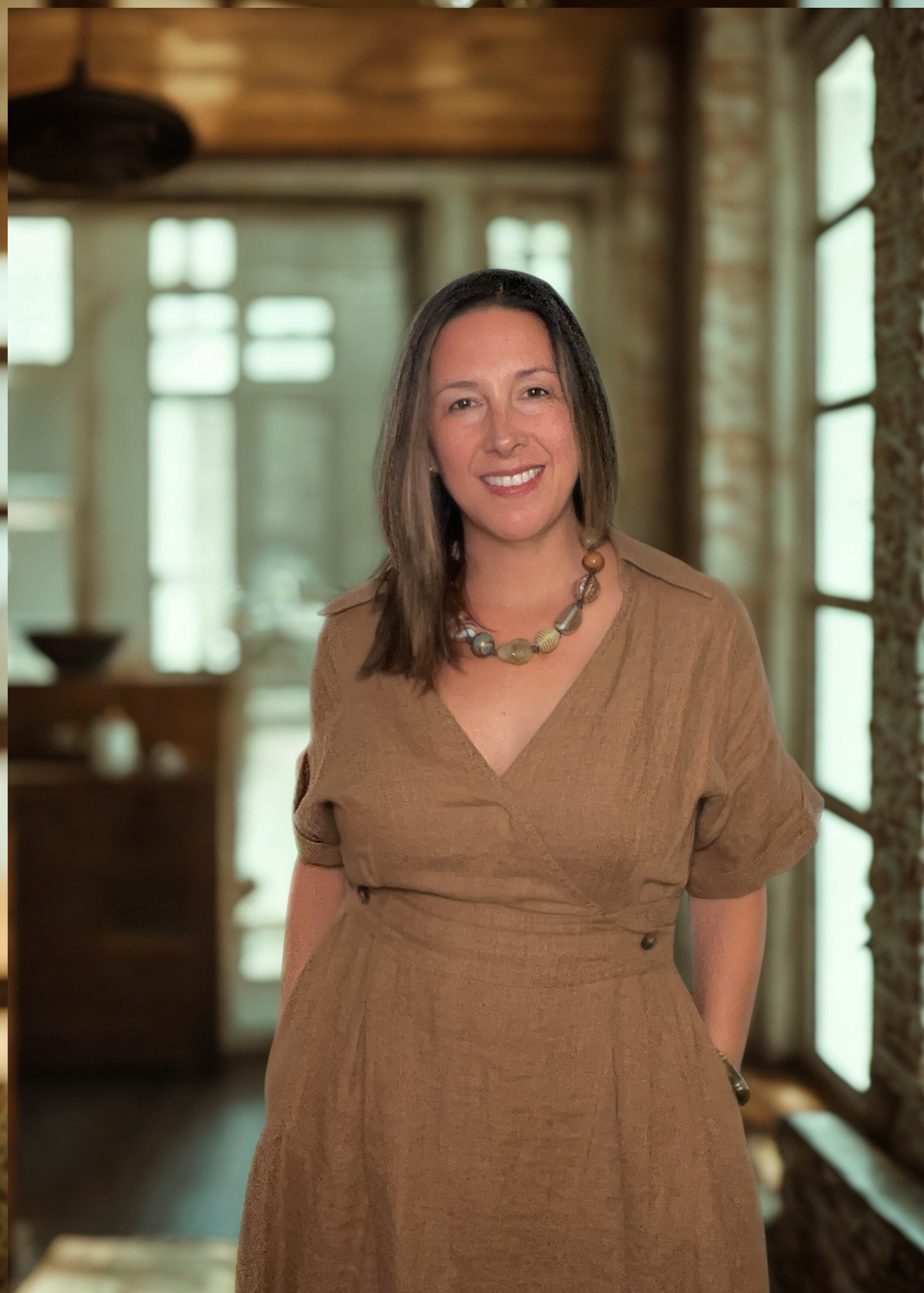 Fiona Grant Leydier, founder of The Inflection Method, standing in a warm, rustic space — embodying grounded confidence and approachable elegance.