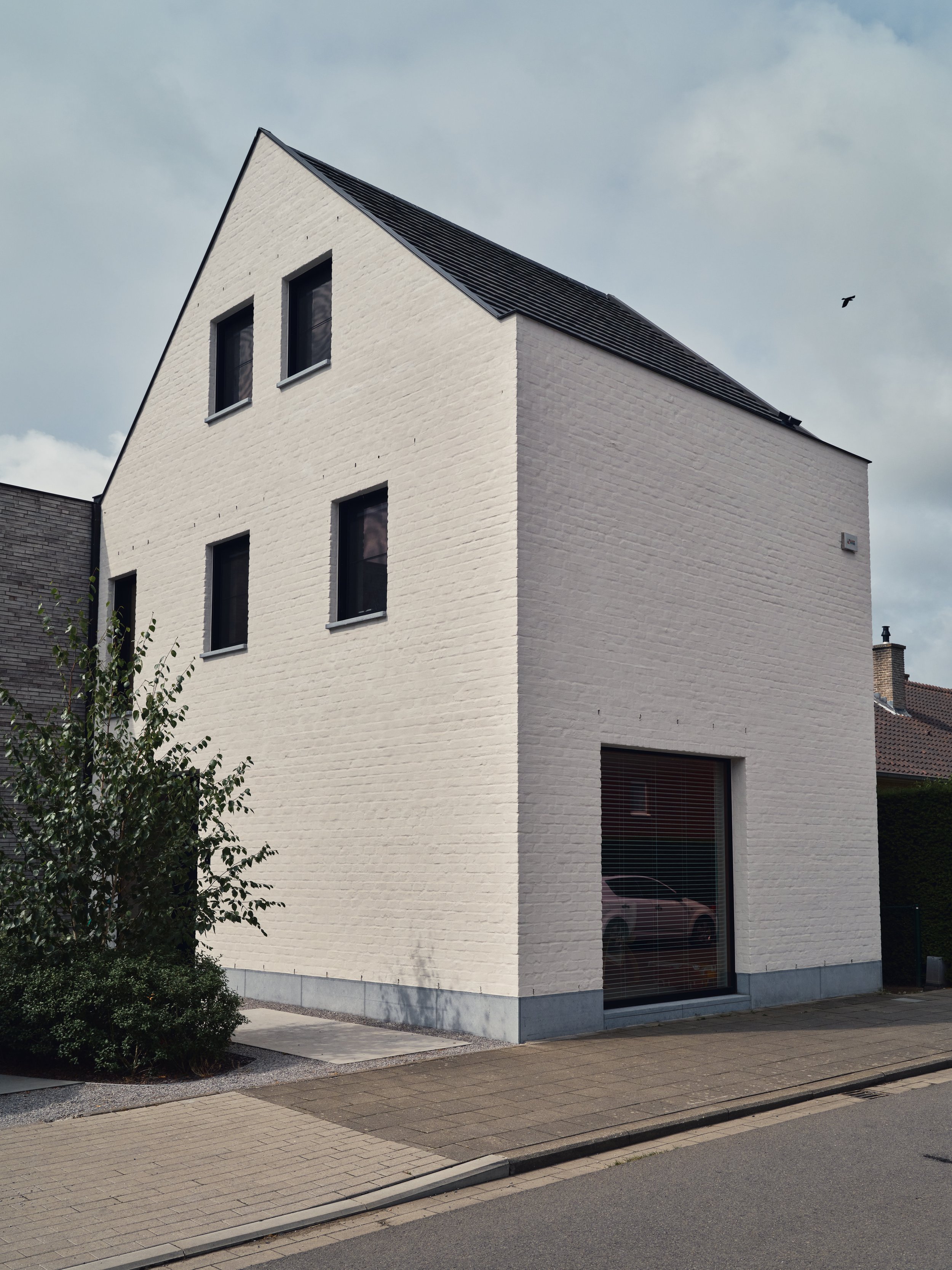Moderne wit geschilderde woning voorzien van Reynaers aluminium ramen en deuren, type masterline 8 en voorzien van inbouw zonwering, type Renson Fixscreen MS7 te Kalfort, Antwerpen dat geplaatst is door Leroy-Alu