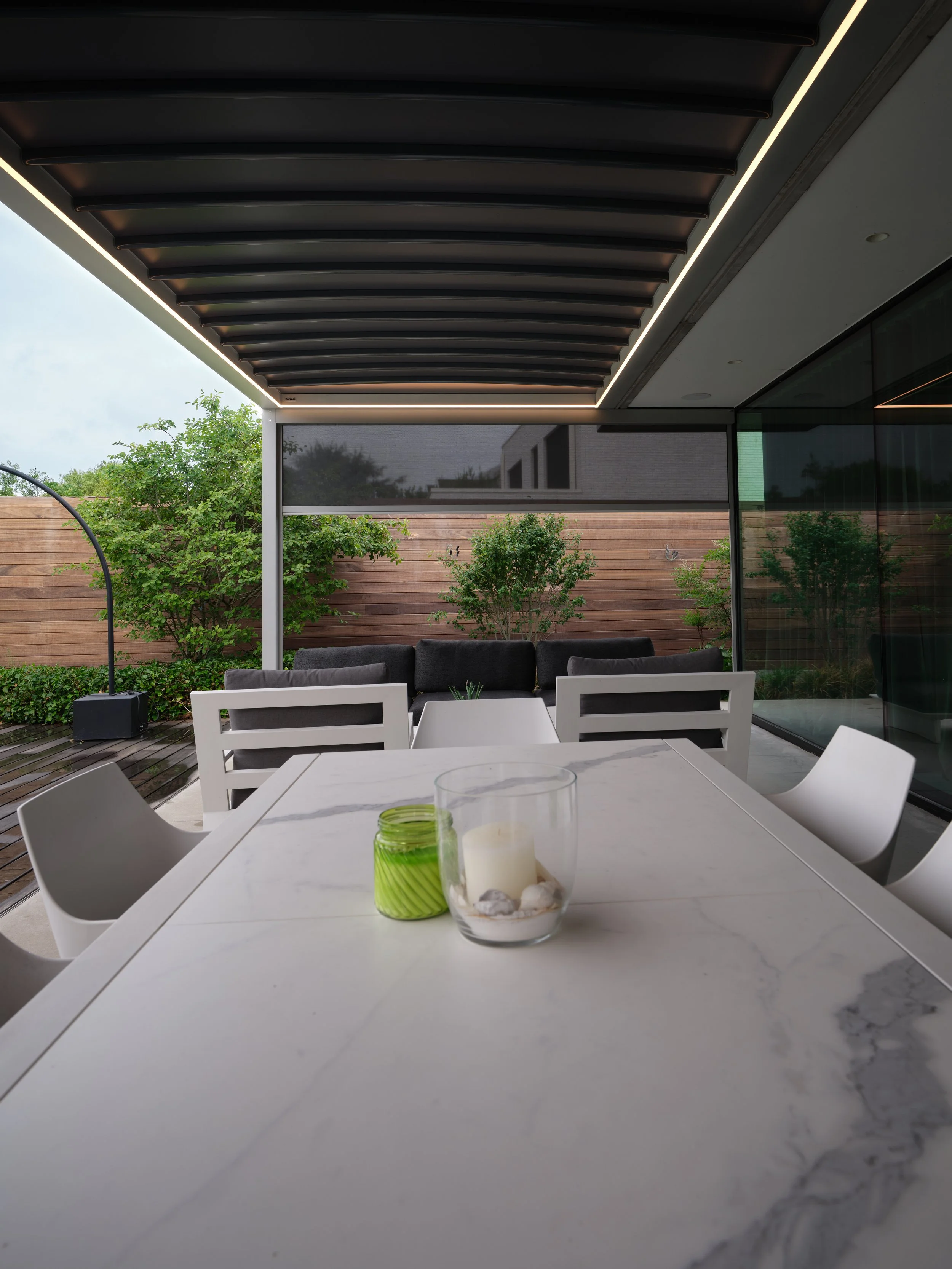 Moderne Villa voorzien van een Corradi vouwdoekdak, type Alba Butterfly in grijs frame met donker doekdak, geplaatst te Buggenhout, Oost-Vlaanderen door Leroy-Alu