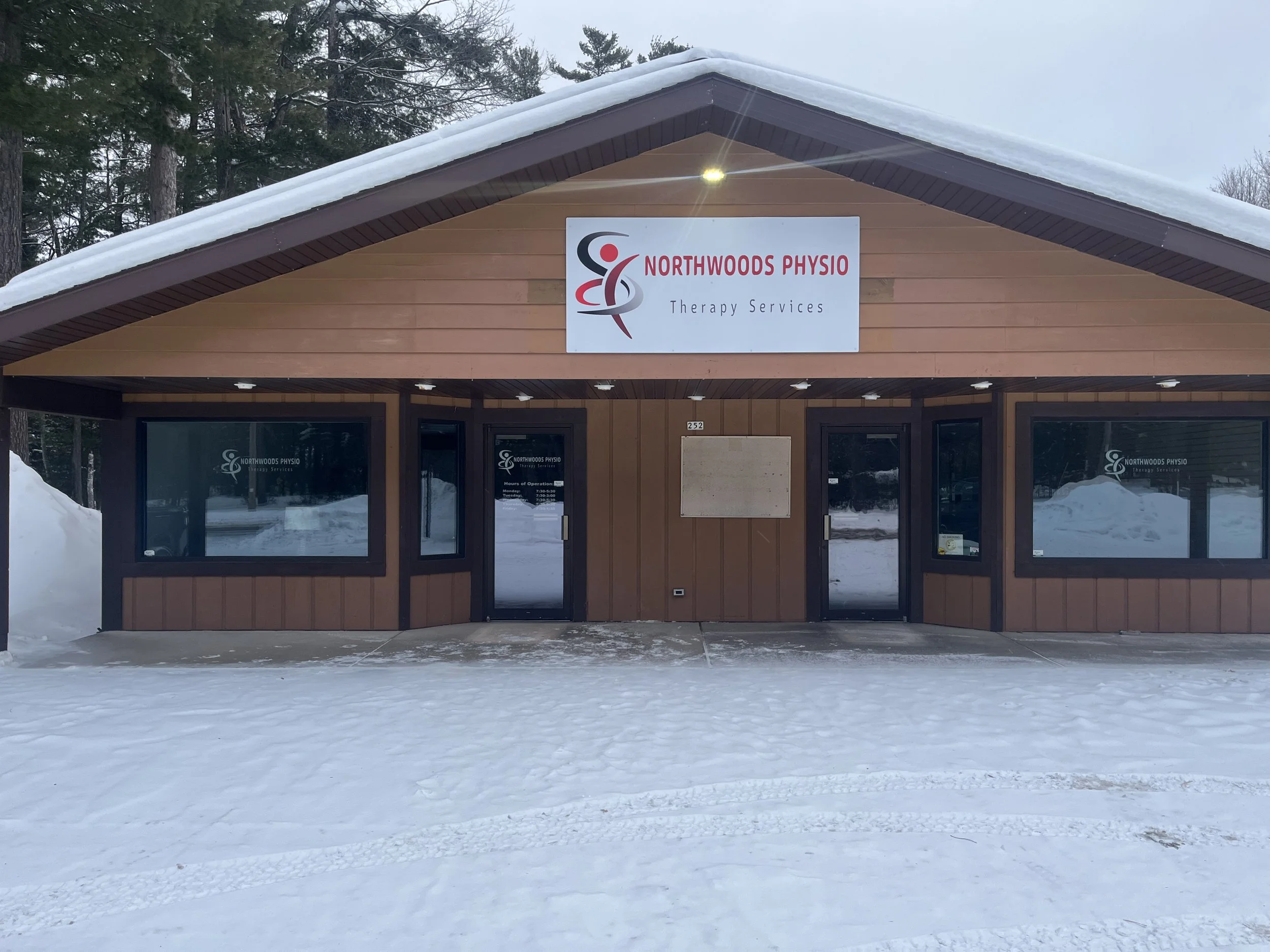 Front view of Northwoods Physio Therapy Services clinic building in snowy landscape.