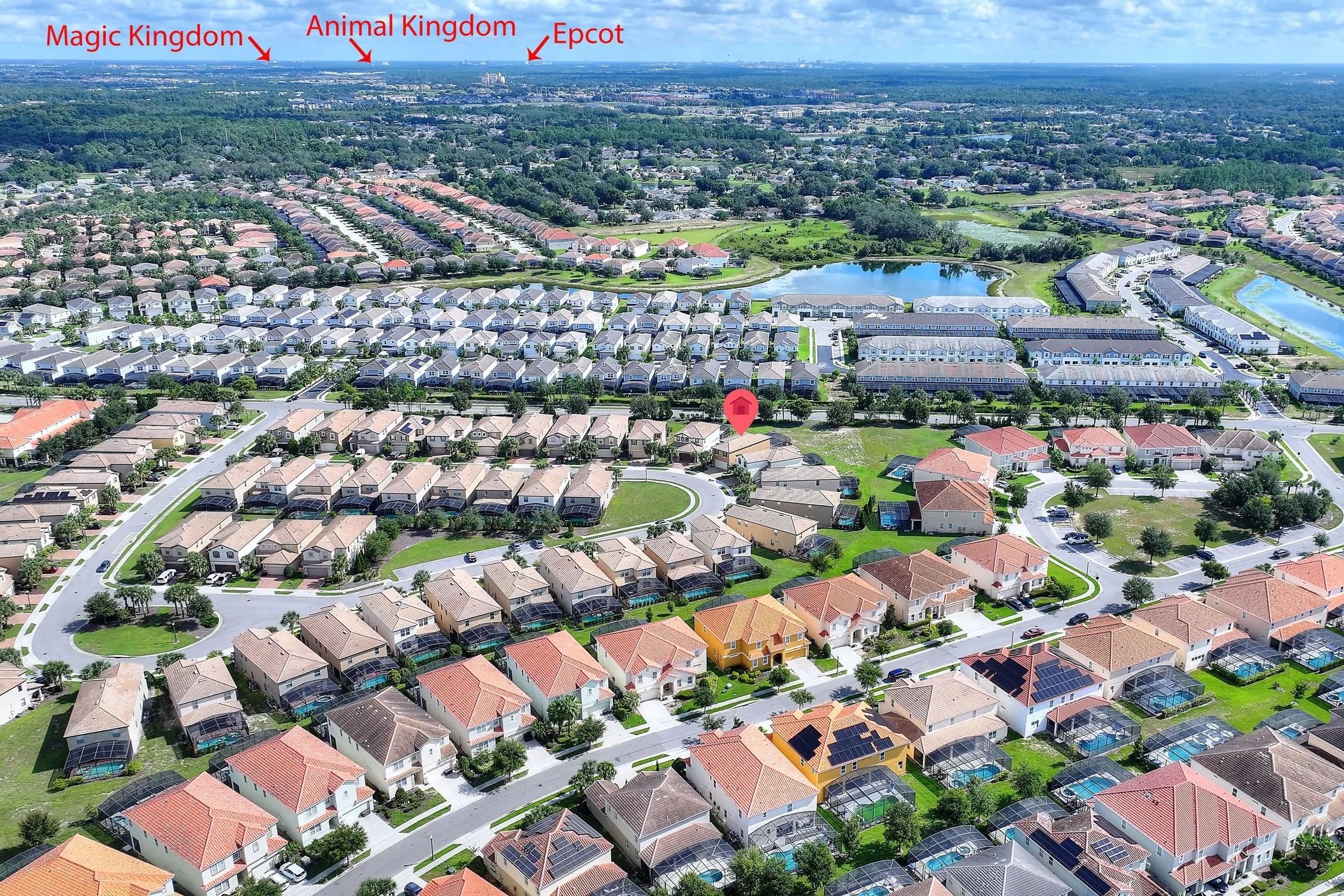 Aerial view of a residential neighborhood with houses, roads, lakes, and green spaces. In the distance, there are labels pointing to Magic Kingdom, Animal Kingdom, and Epcot, indicating the theme parks in Orlando, Florida.