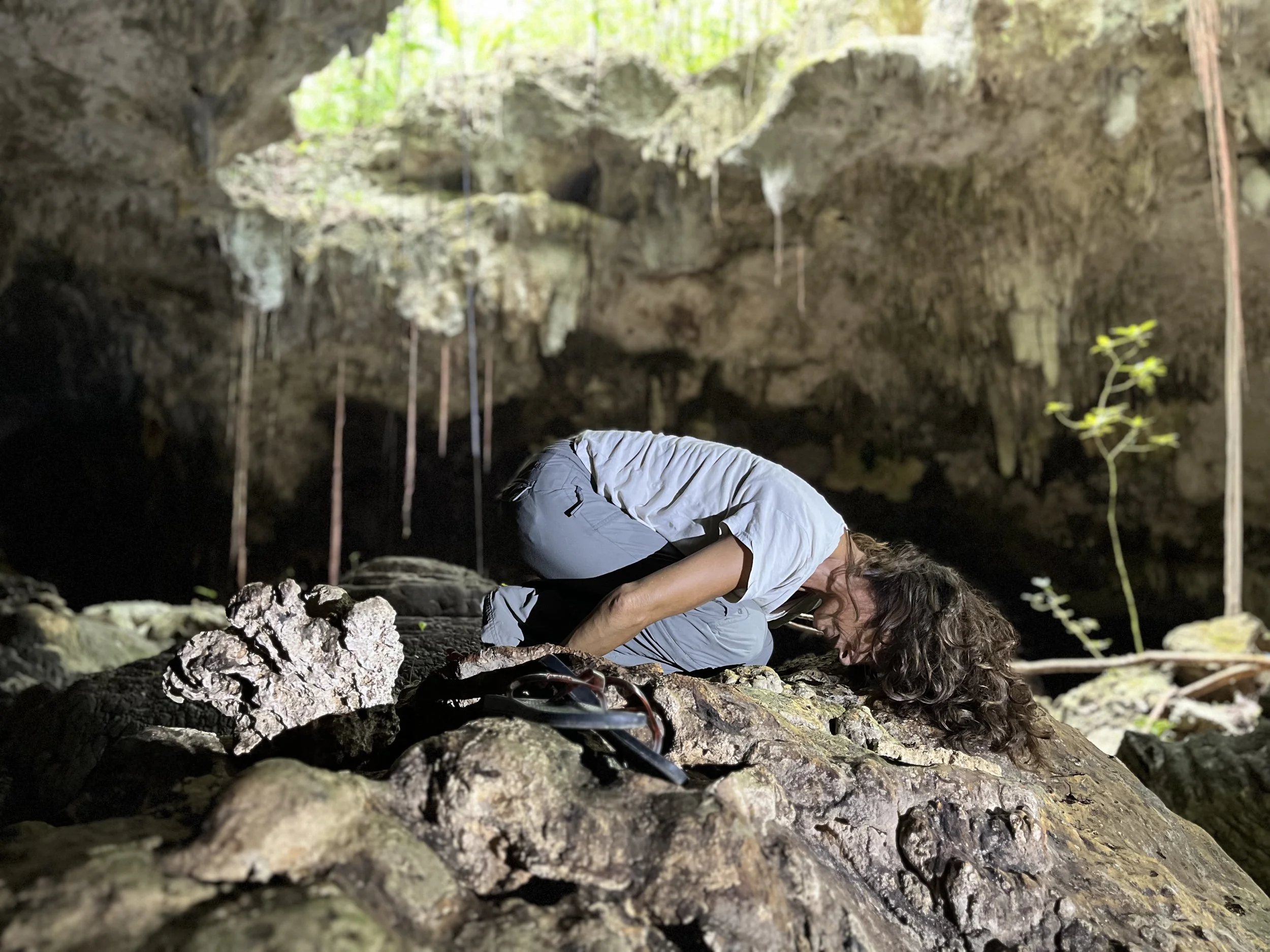 woman in cave laying on a rock.jpg
