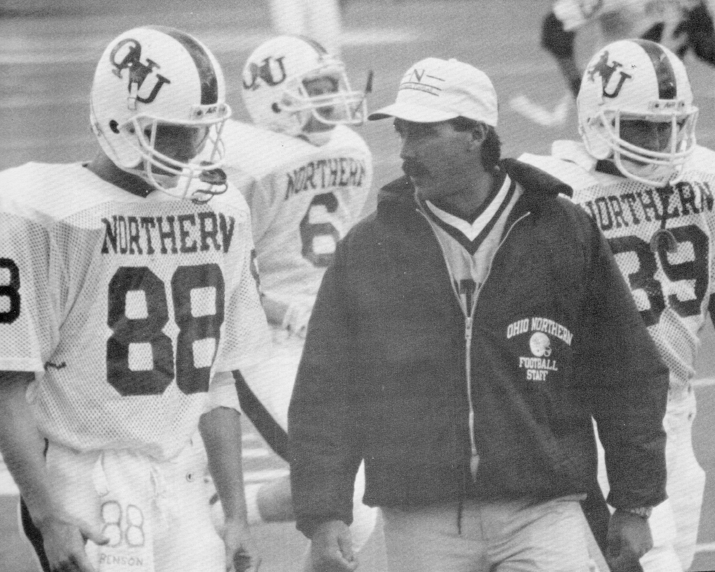 Tom as a football coach talking to players on the sidelines, with players wearing helmets and jerseys labeled 'Northern' and the coach wearing a jacket with 'Ohio Northern Football' logo.