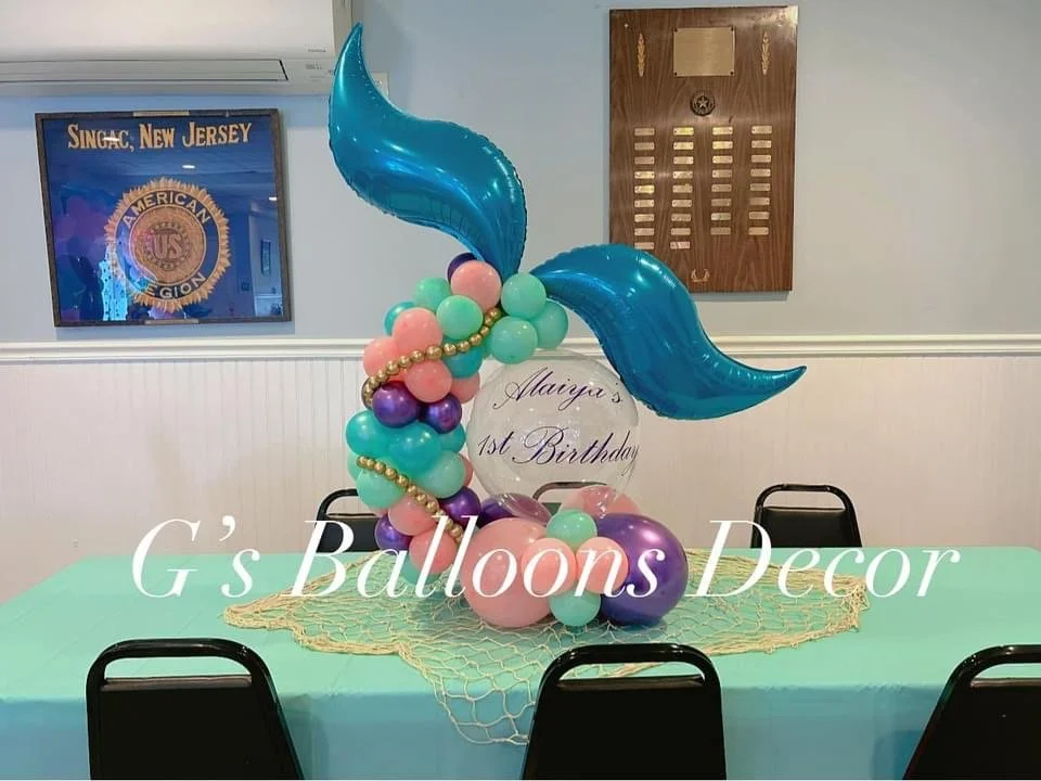 Balloon arrangement with a mermaid tail design in blue, pink, purple, and green balloons.