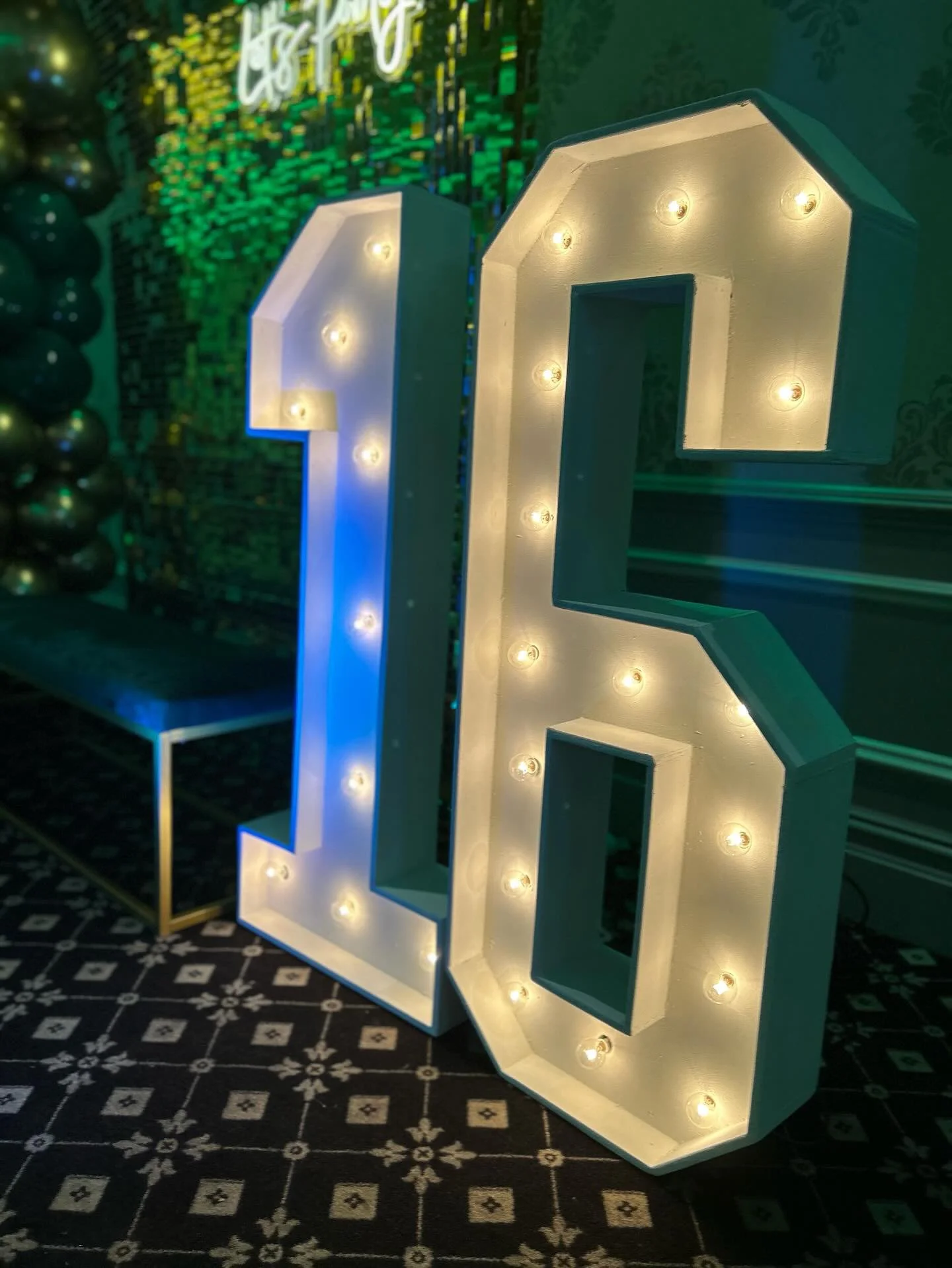 Large illuminated numbers '16' with bulbs inside, indicating a 16th birthday celebration.