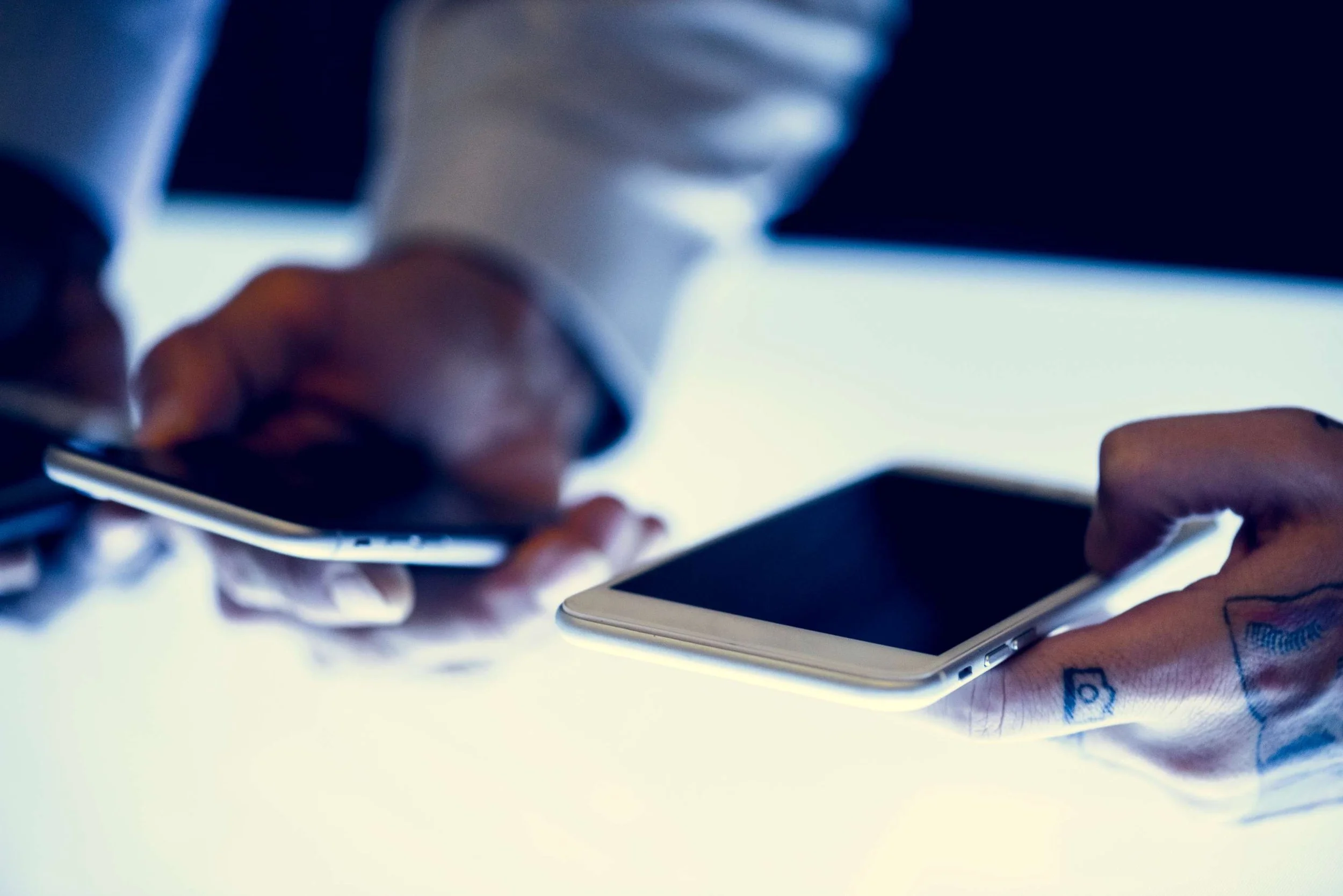 a man holding two smart phone devices