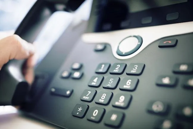 an image of a office telephone that is black and silver