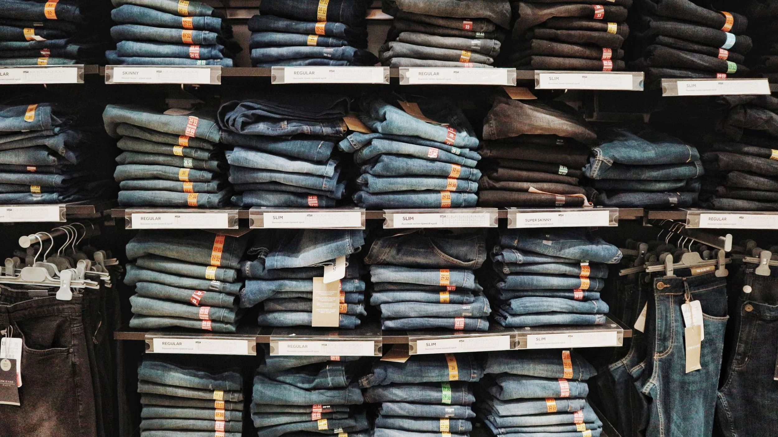 denim blue jeans stacked on shelves in a retail store