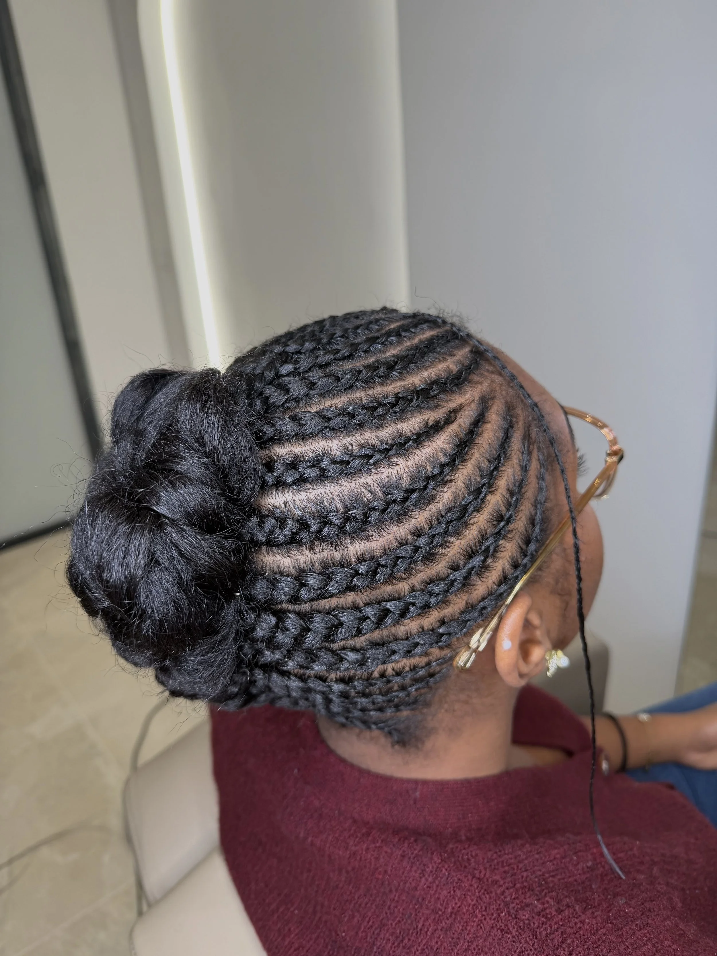 Une femme avec des cheveux en tresses africaines, coiffées en chignon. tresses sur cheveux naturels