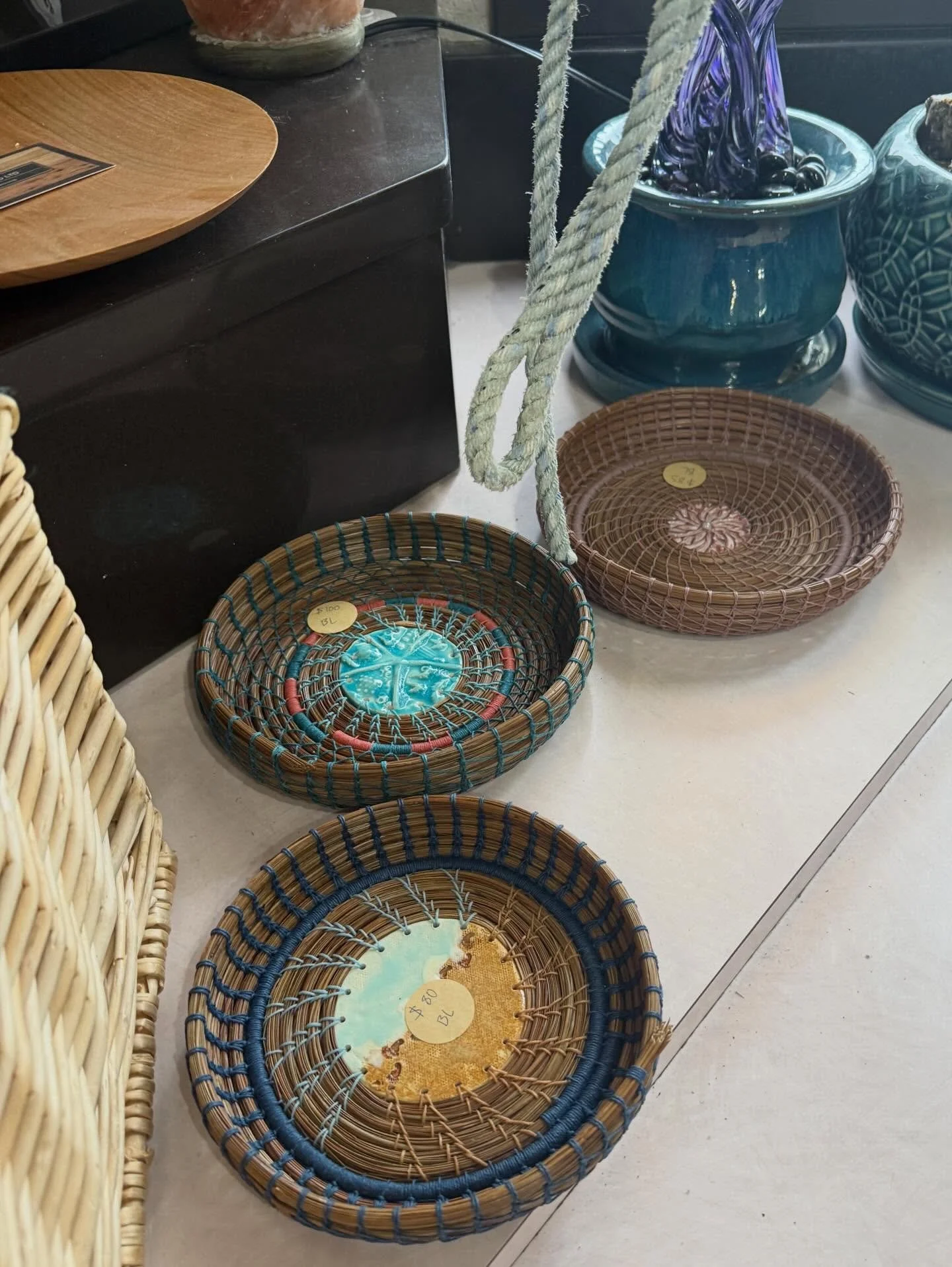 Various woven baskets and ceramic planters on display in a store.