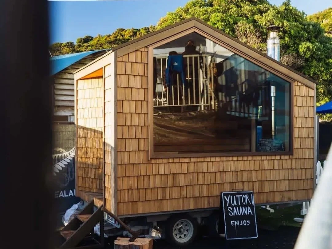 The Yutori Sauna is situated outdoors with trees in the background, and a sign that reads "Yutori Sauna Enjoy."