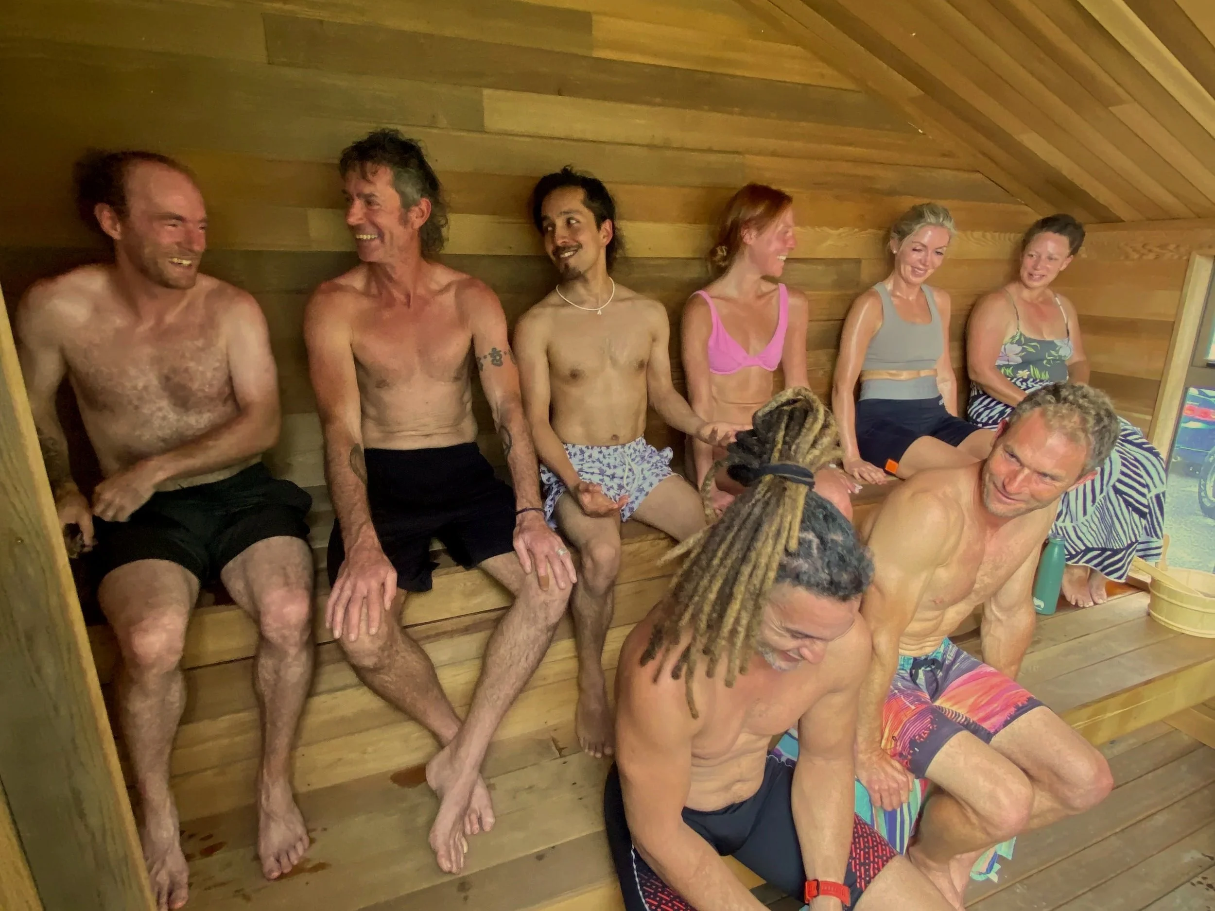 Group of people sitting in the Yutori Sauna, smiling and talking.