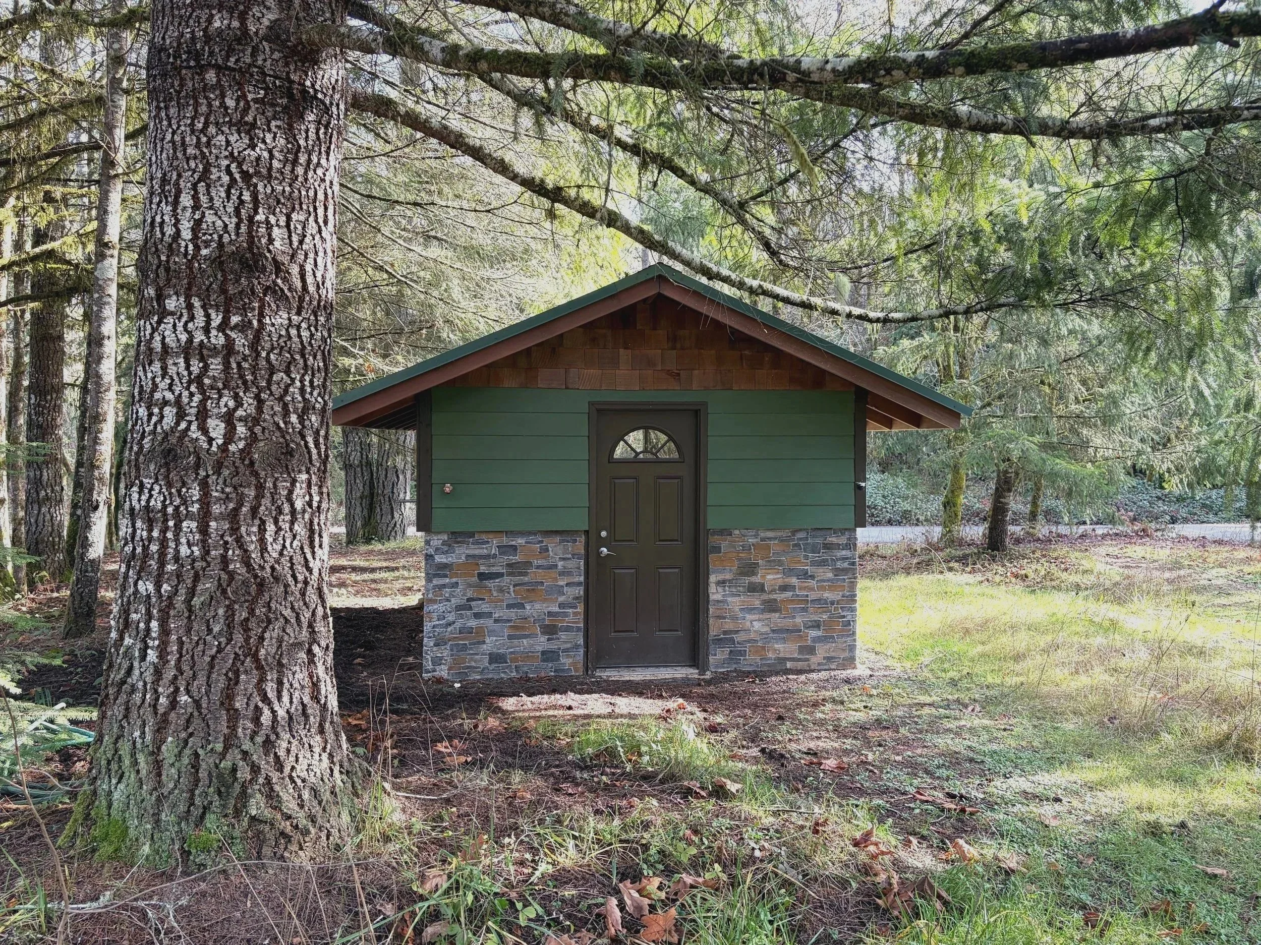 A pump house on forested property, upgraded to a stone wall foundation and fireproof siding.