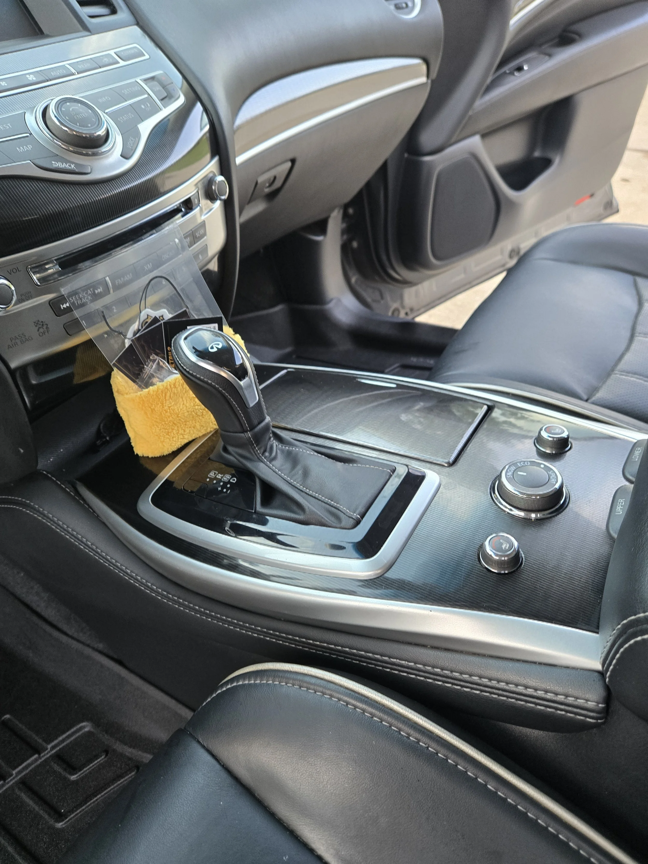 Interior of a modern car showing the center console with gear shift, control knobs, and part of the dashboard.