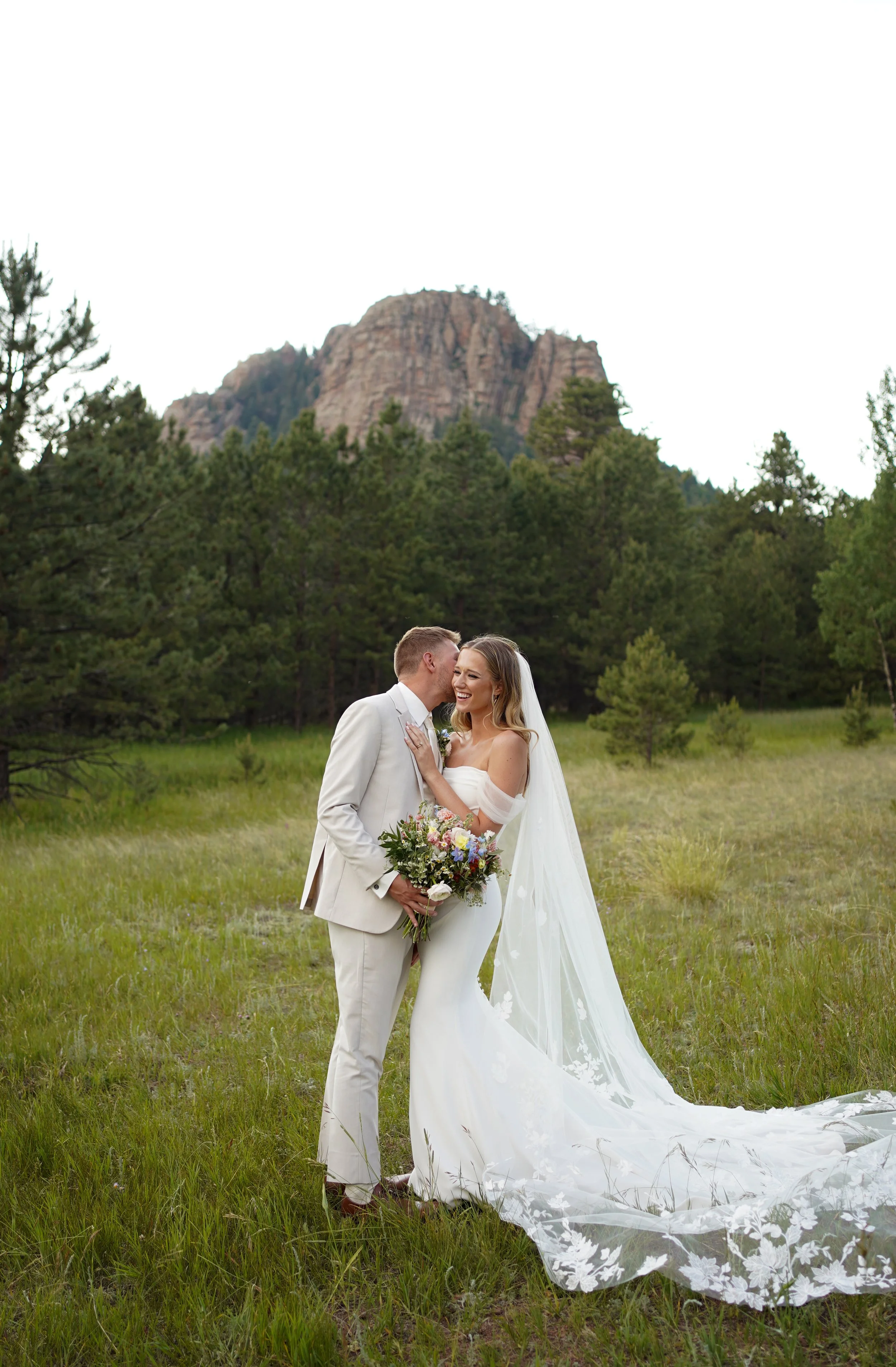 Couple laughing in a field on wedding evening in Pine, Colorado