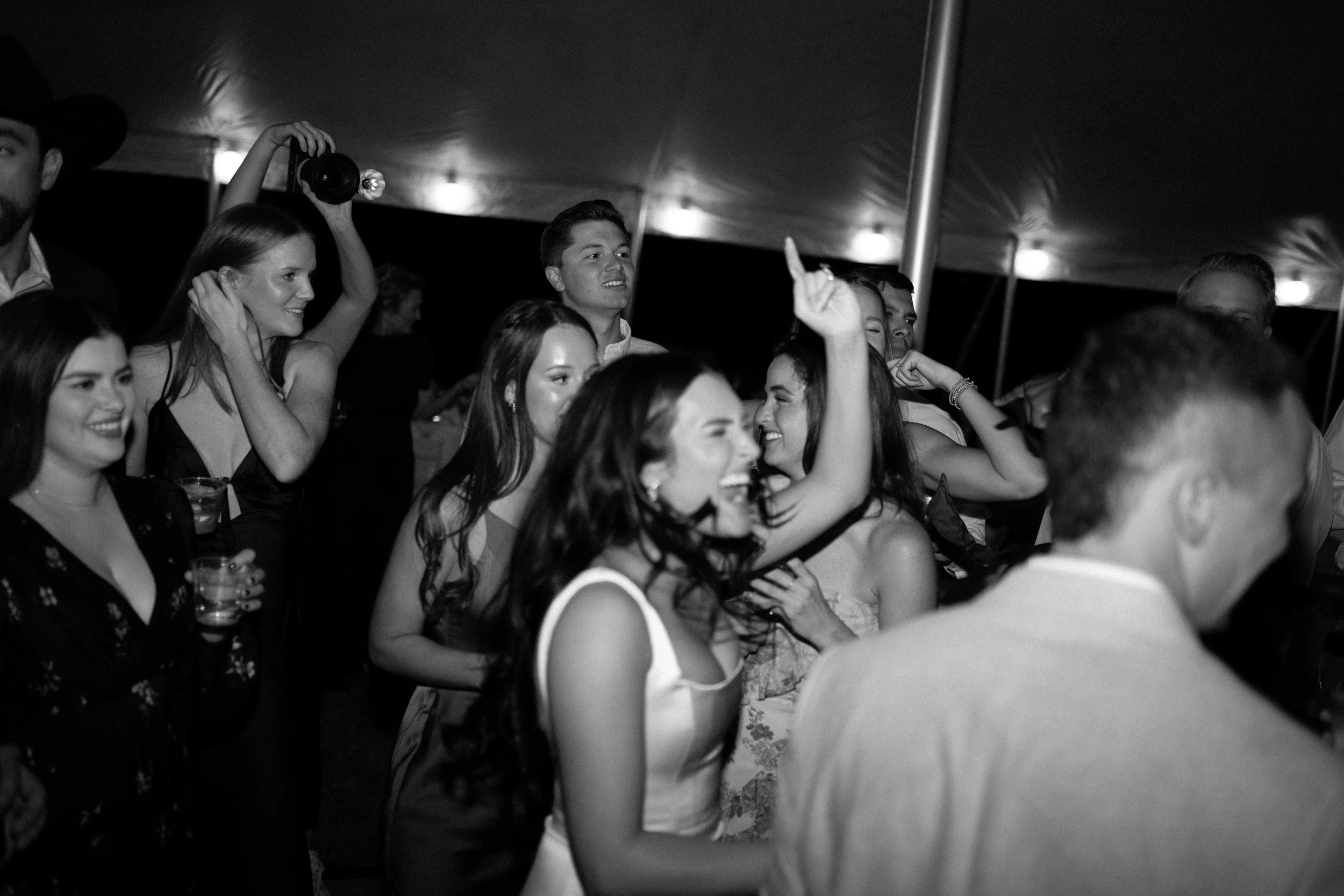 Candid reception dance floor moment in black and white during a Fort Worth backyard wedding.