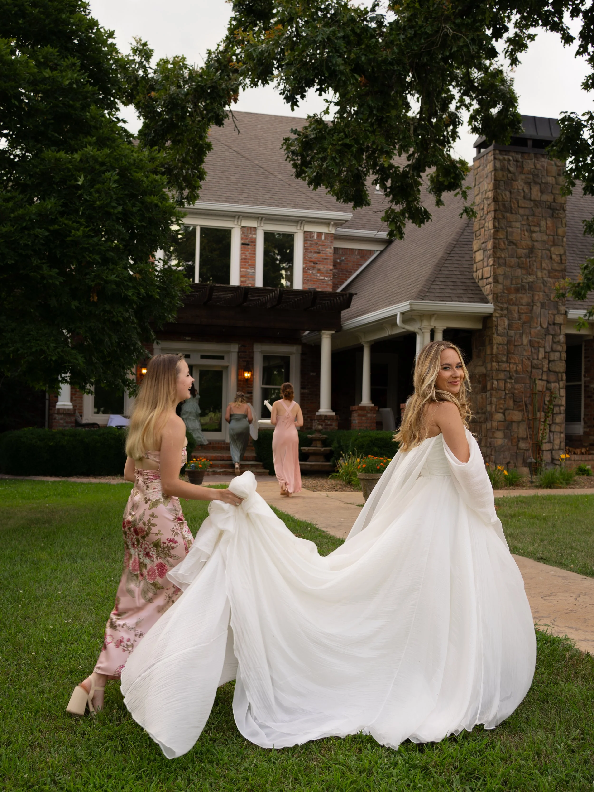 Bride and maid of honor walking by house