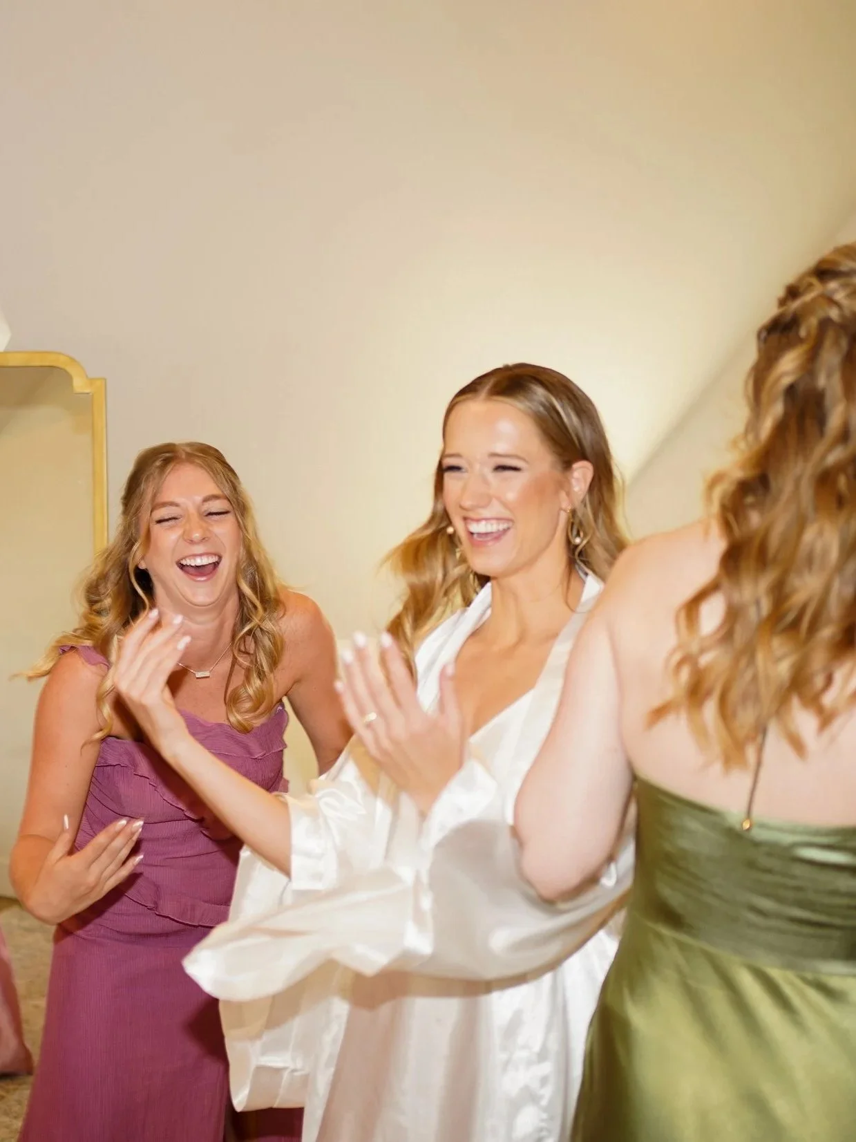 Bride and bridesmaids laughing while getting ready candid in Pine, Colorado