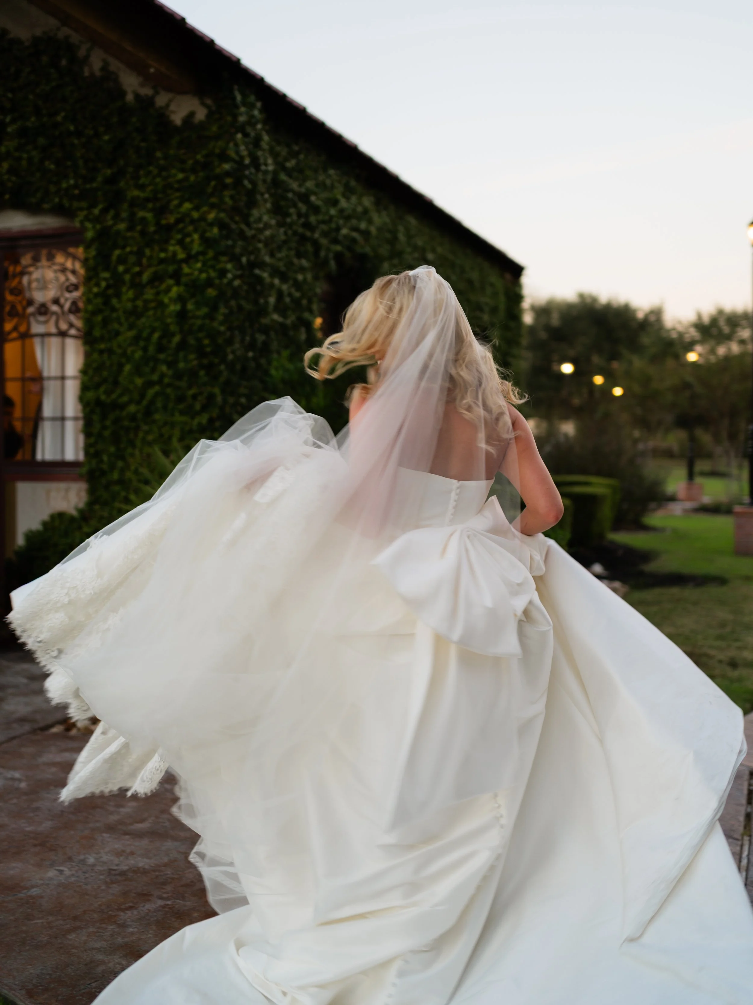 A graceful movement shot of the bride in Montgomery, TX, as her gown flows naturally through the garden setting at golden hour.