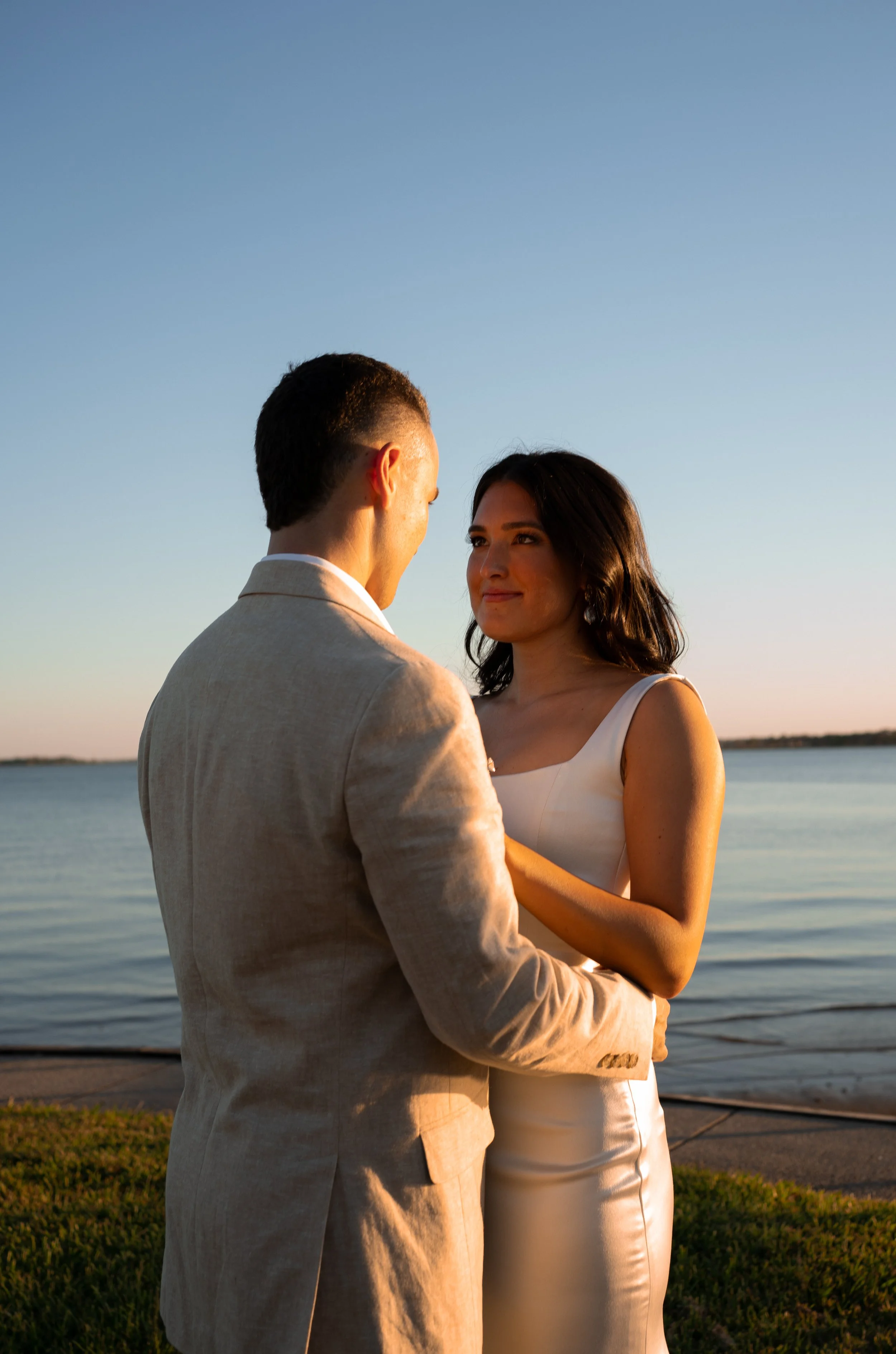 Romantic couple portrait by the water during golden hour at a backyard wedding in Fort Worth, Texas.