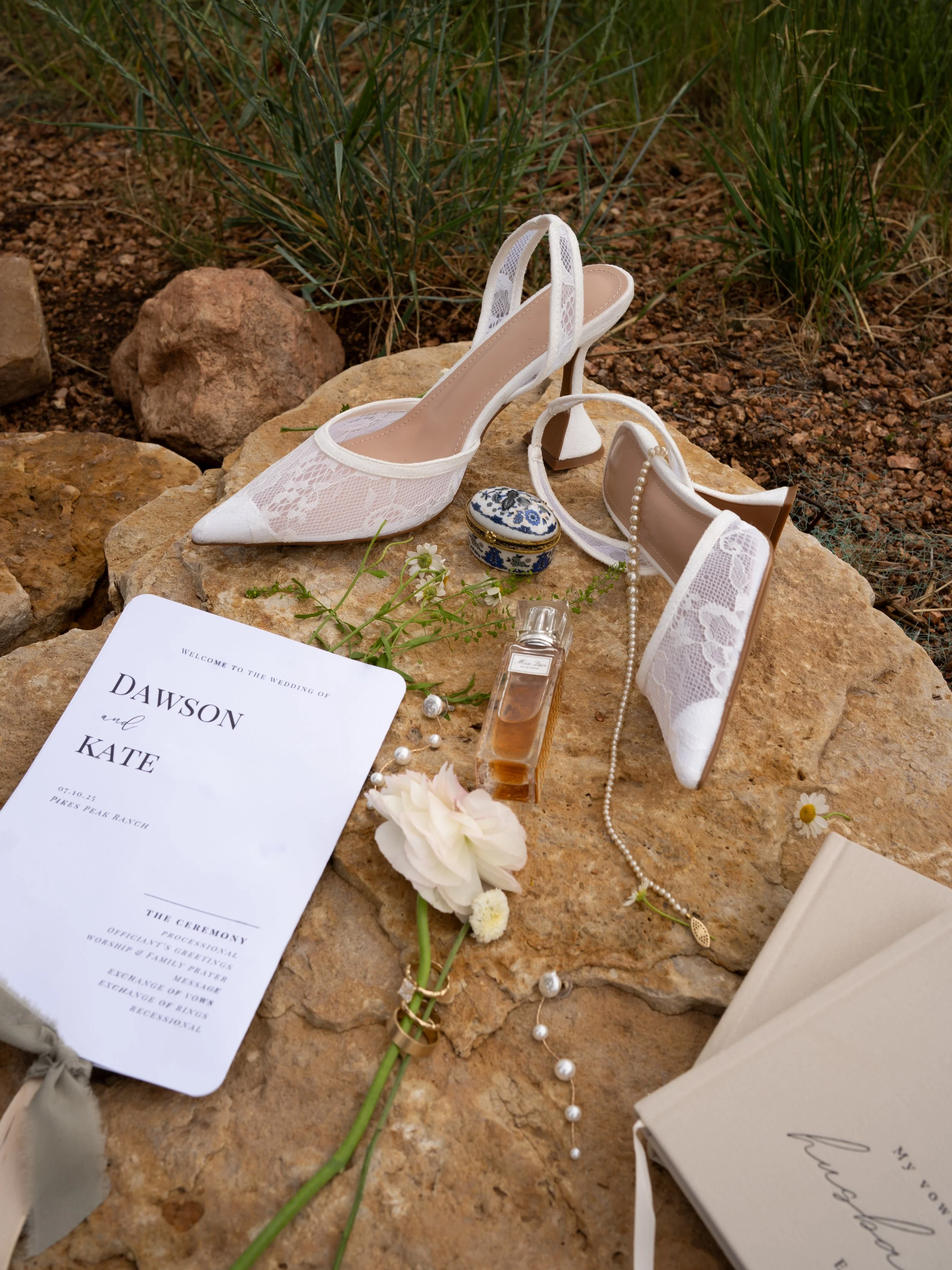 A refined detail composition at Pikes Peak Ranch, highlighting invitation suite, shoes, and natural textures.