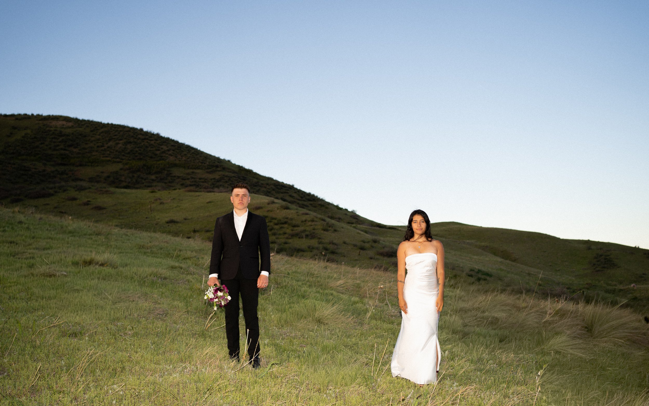 Couple standing apart in an open landscape during an editorial wedding portrait in Boulder Colorado