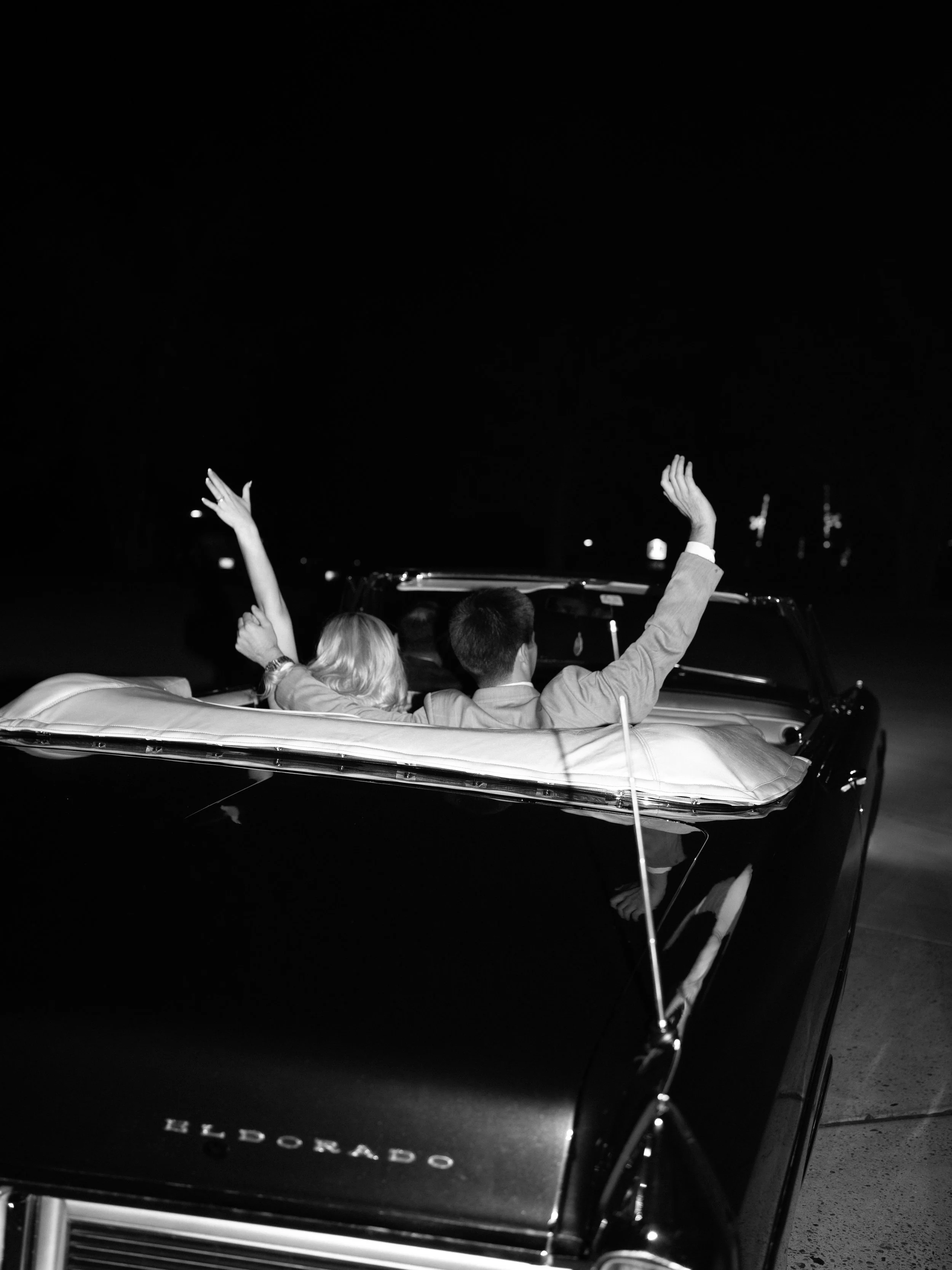 A cinematic black-and-white send-off in Montgomery, Texas, as the couple celebrates in a vintage getaway car under the night sky.