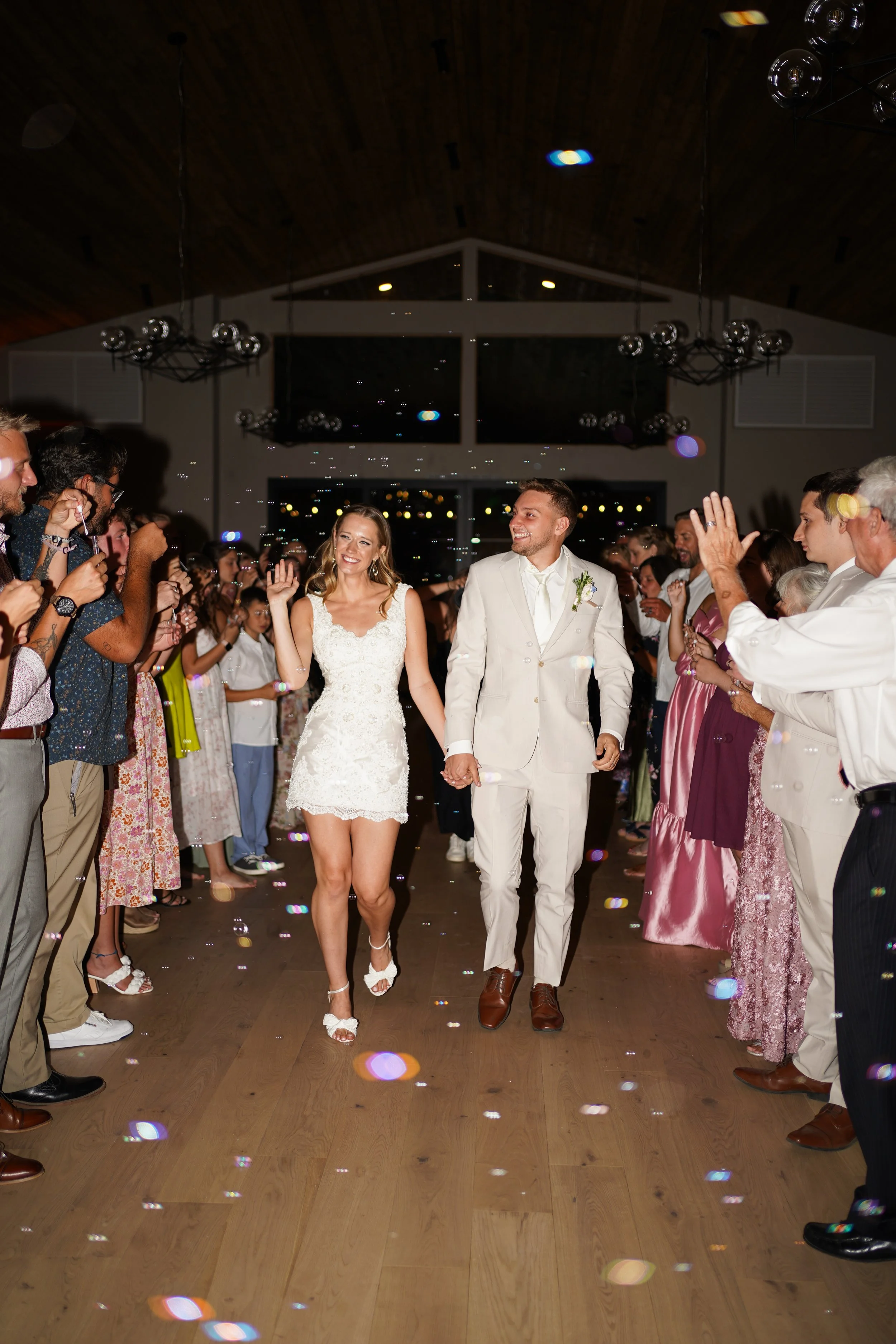 Send off flash photography couple waving bye and friends and family cheering
