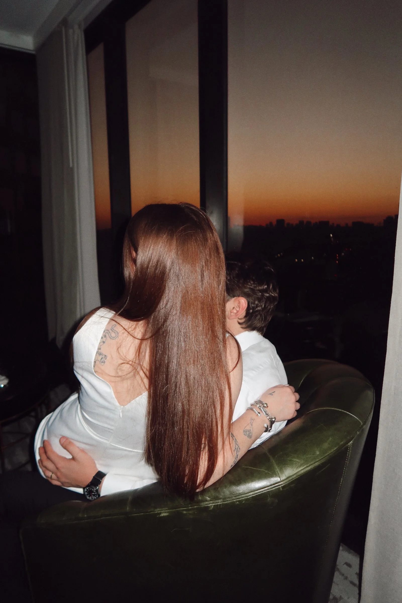 A warm, intimate embrace in Houston, Texas, as the couple shares a quiet moment overlooking the evening skyline.