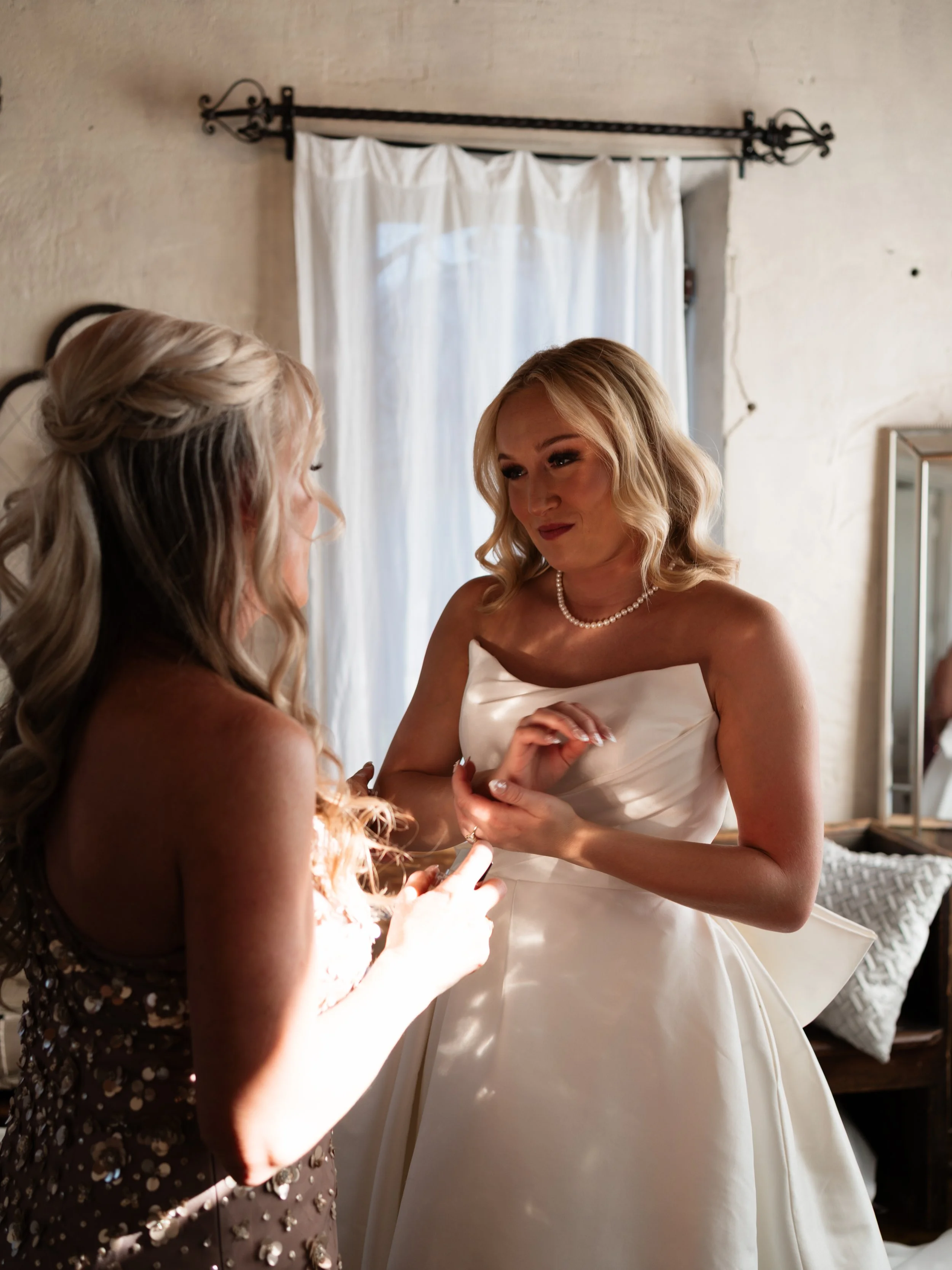 An intimate bridal getting-ready moment in Montgomery, Texas, as soft window light highlights the bride’s final touches before walking down the aisle.
