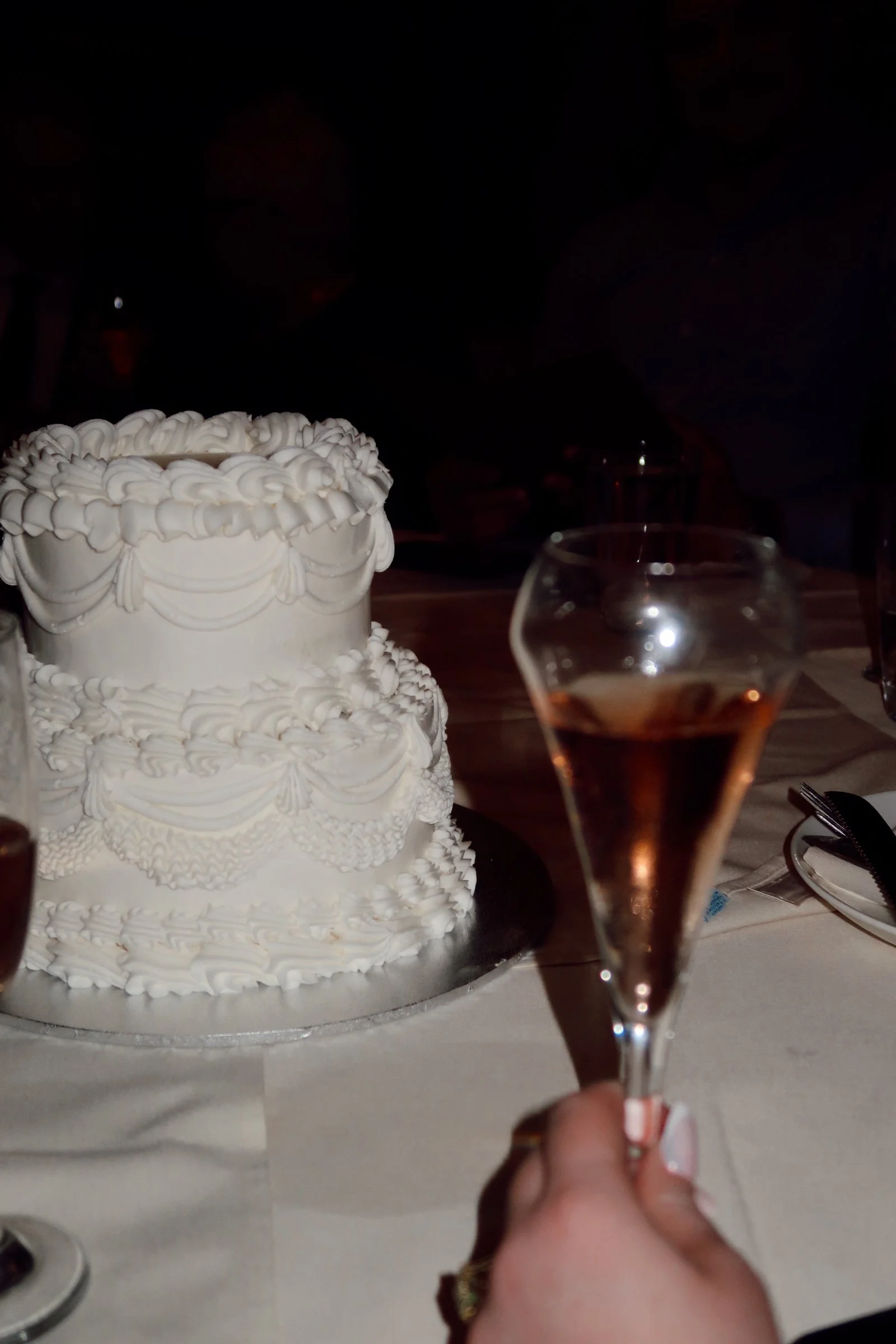 A refined Houston, Texas wedding detail featuring a classic tiered cake paired with champagne, capturing the elegance of the reception.
