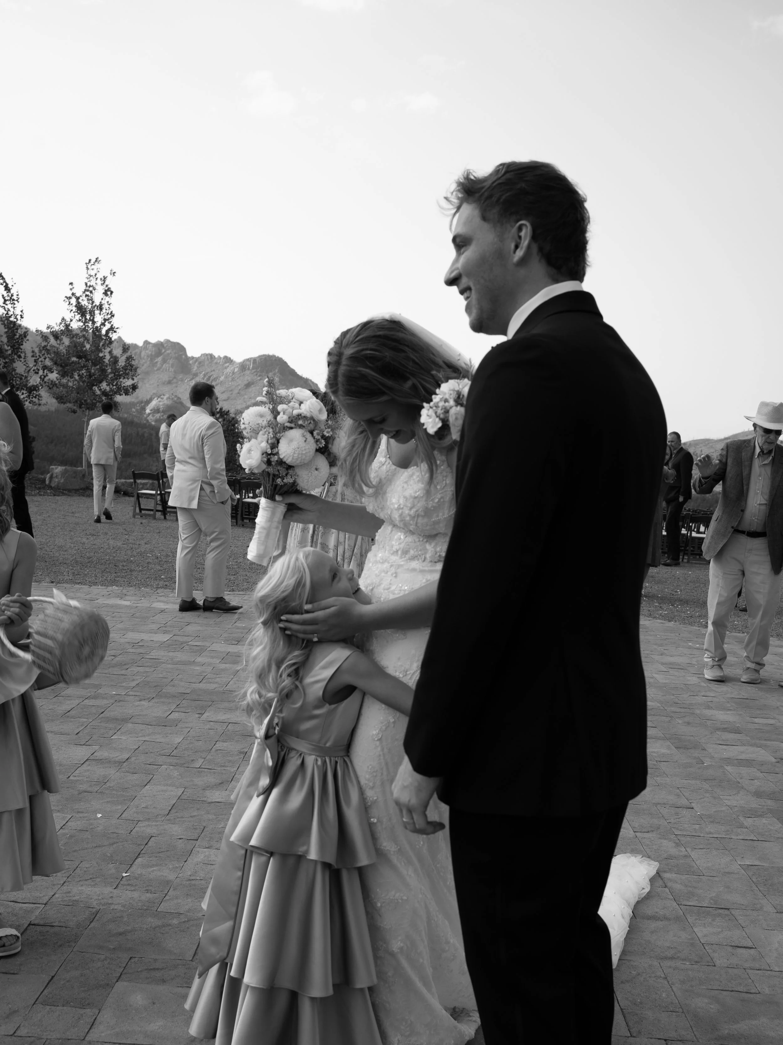A candid black-and-white moment in Woodland Park, CO, capturing guests connecting during cocktail hour.