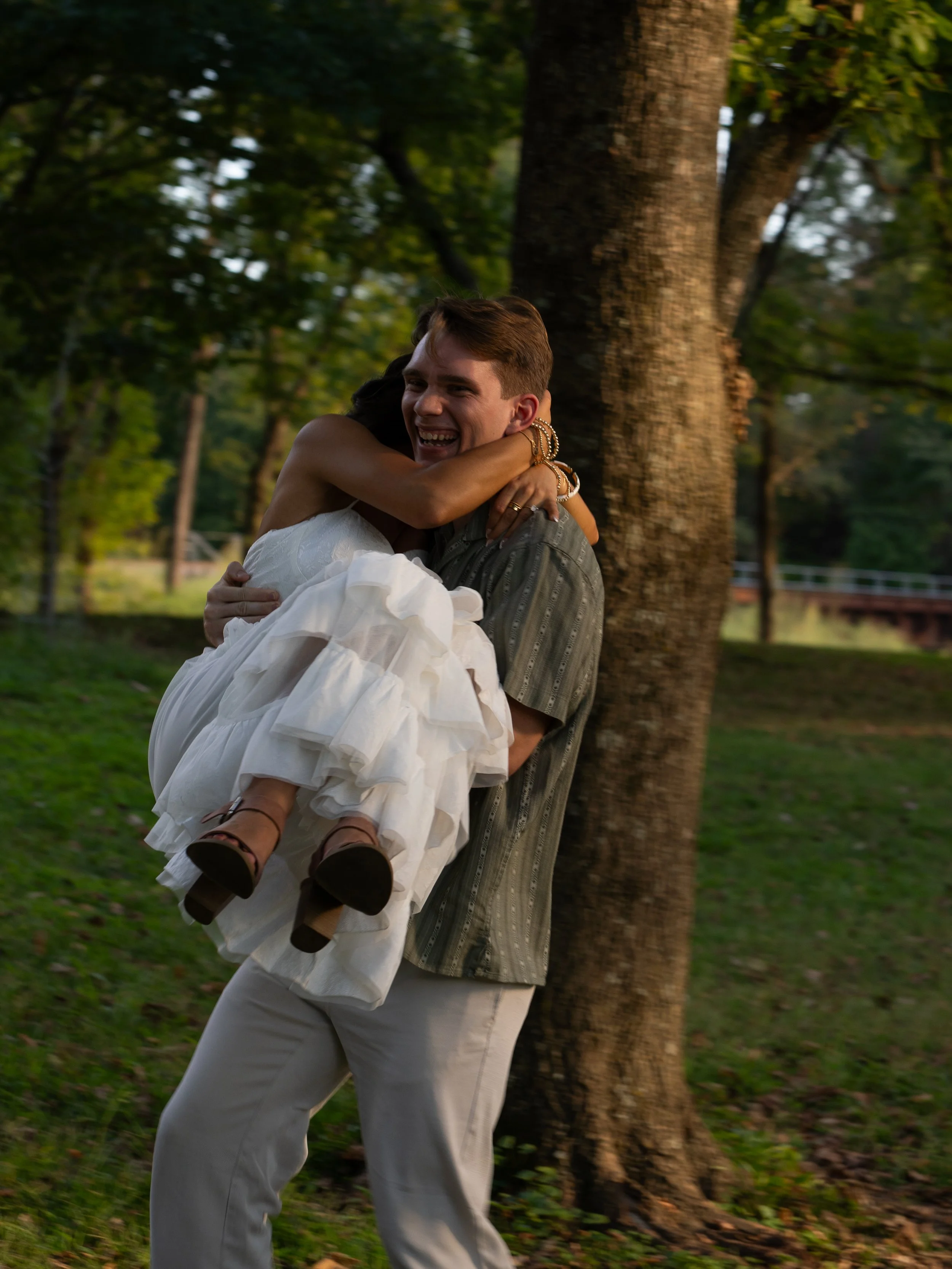 A joyful engagement portrait in Mammoth Springs, AR, capturing movement, laughter, and effortless connection.