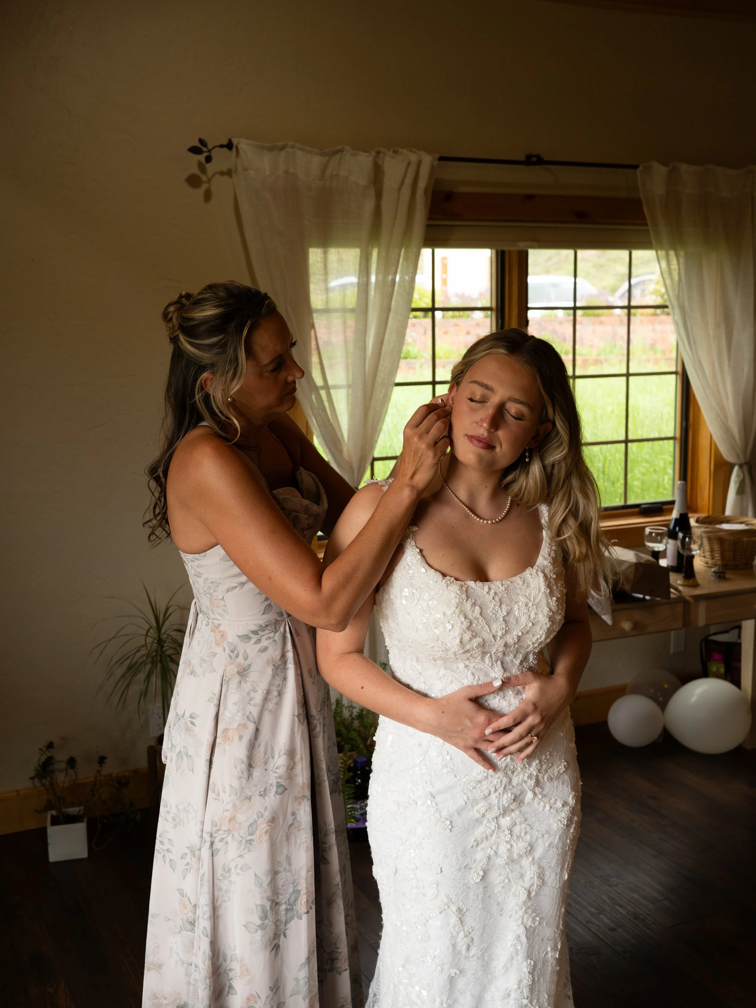 A soft getting-ready moment in Woodland Park, Colorado, as the bride is prepared with care and anticipation.