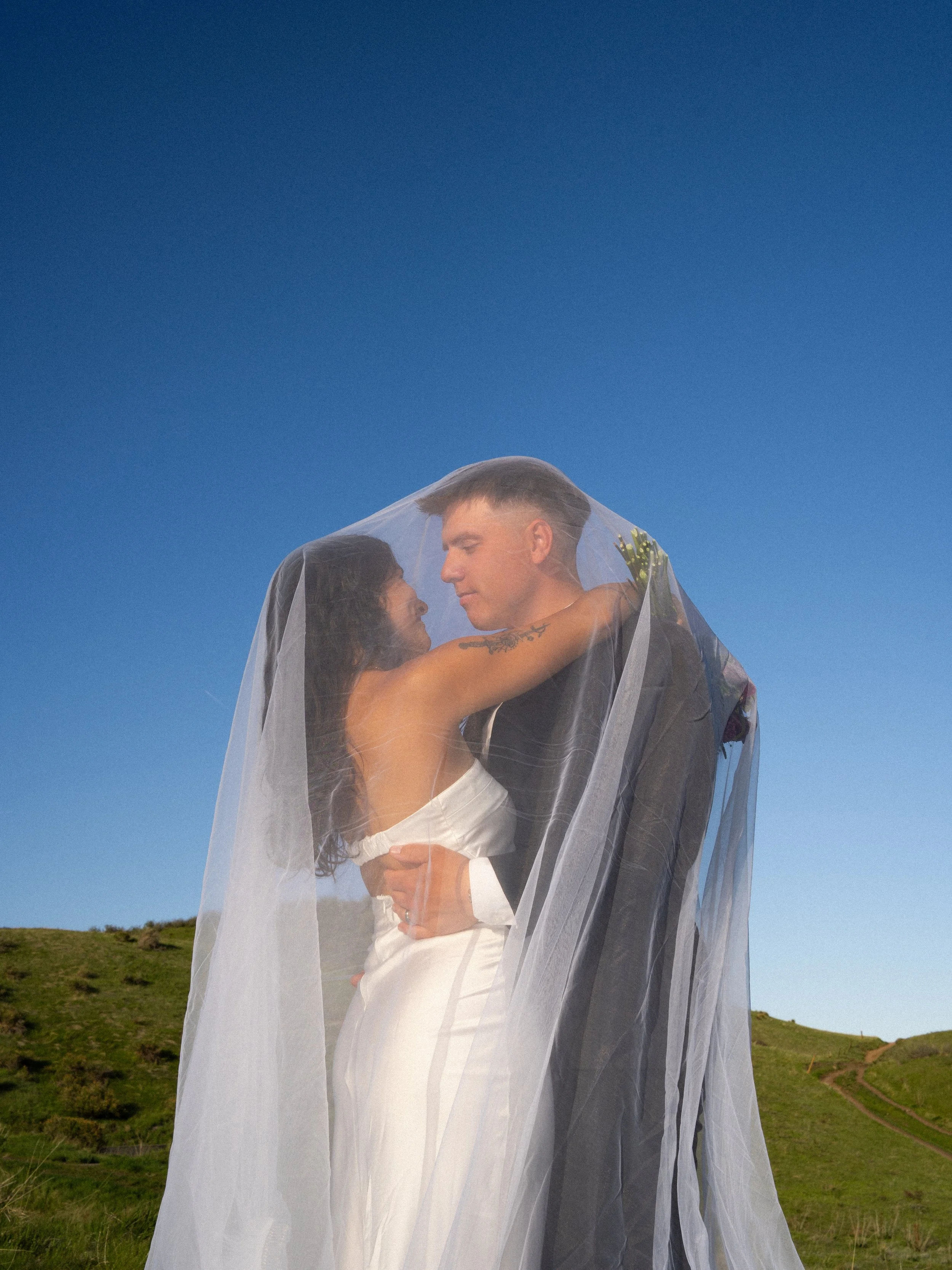 An editorial veil portrait in Boulder, Colorado, capturing intimacy framed through soft fabric and light.