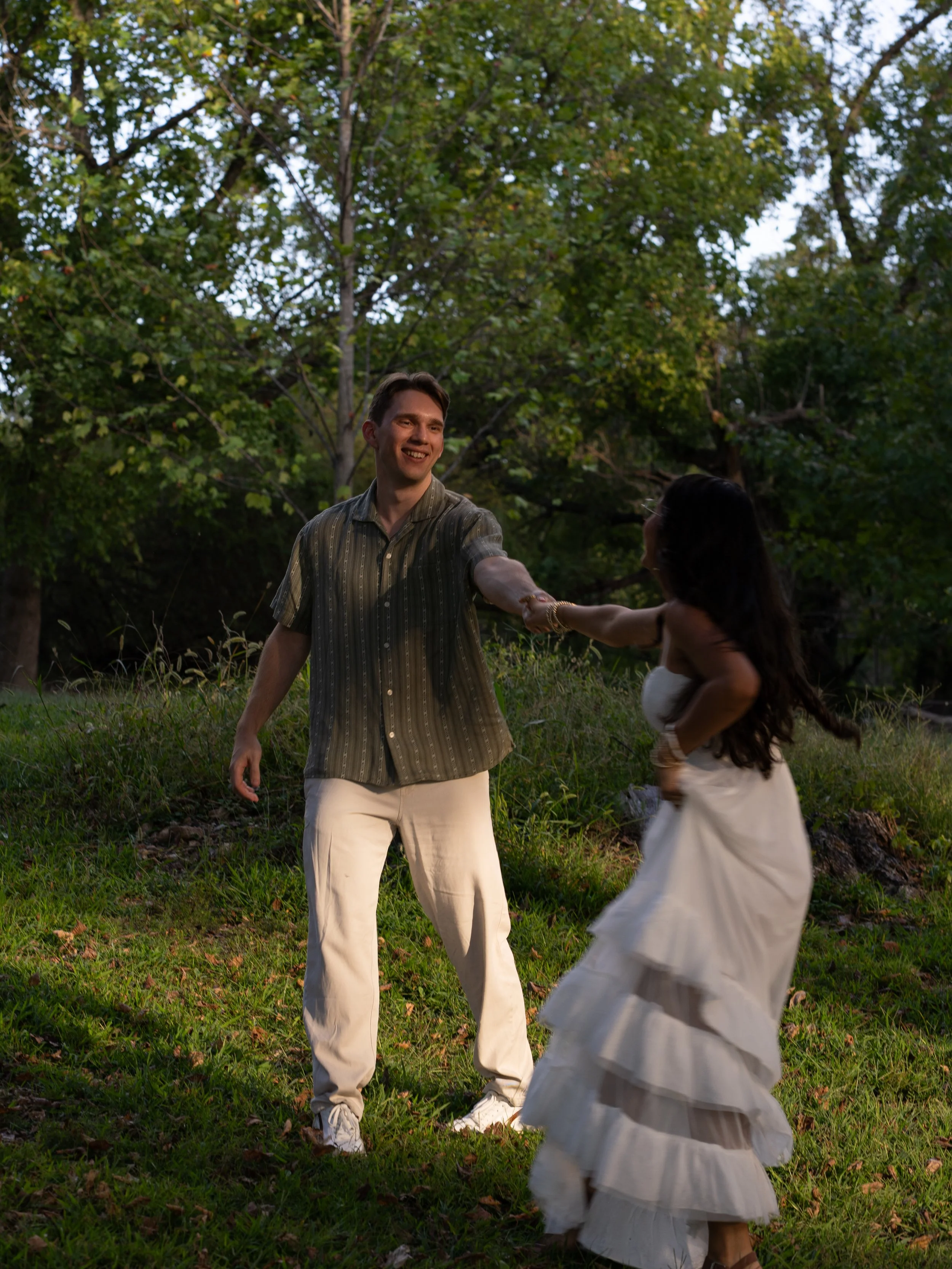 A candid engagement moment in Mammoth Spring, Arkansas, capturing movement, laughter, and golden evening light.
