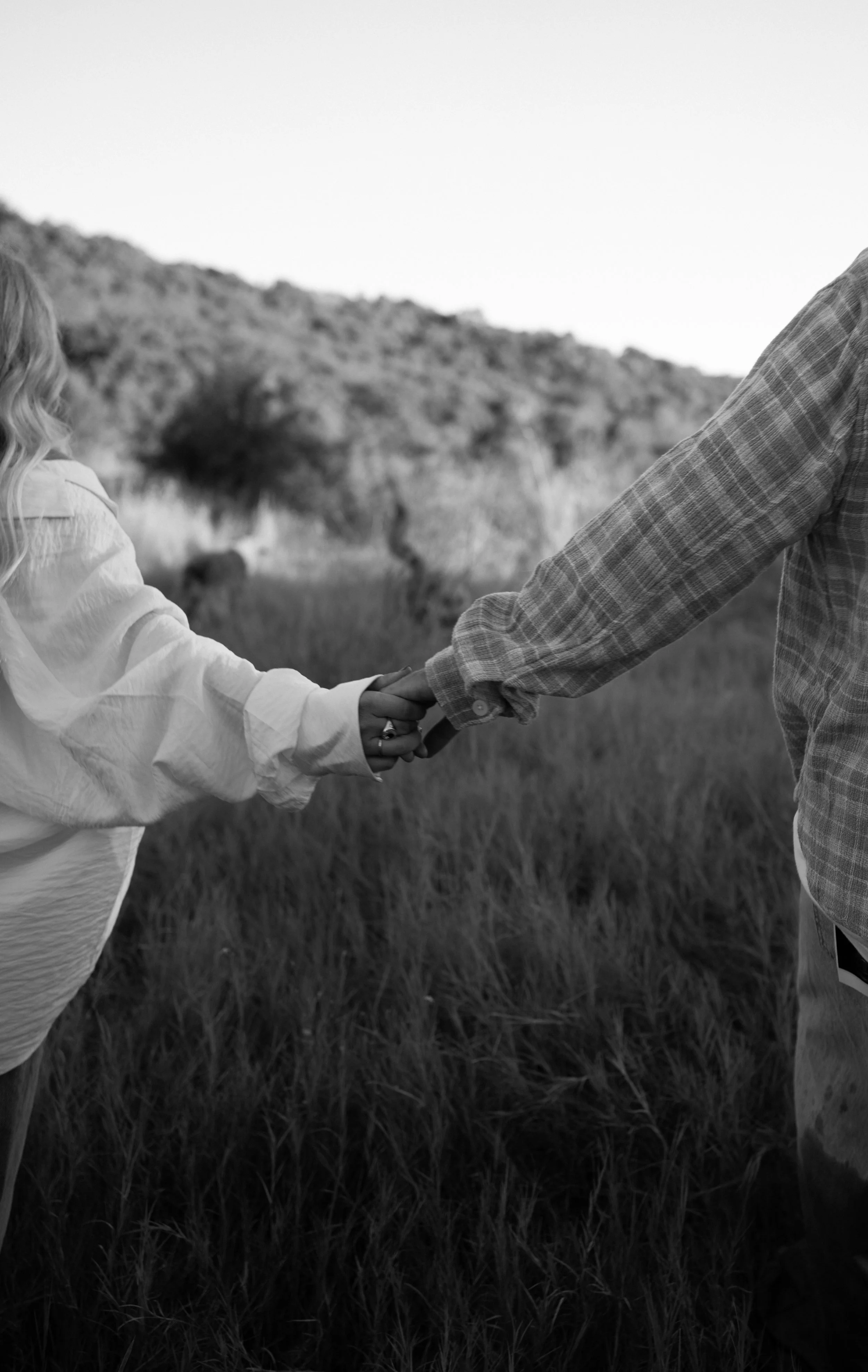 An intimate black-and-white detail in Rainbow, TX, capturing connection through touch and subtle movement.