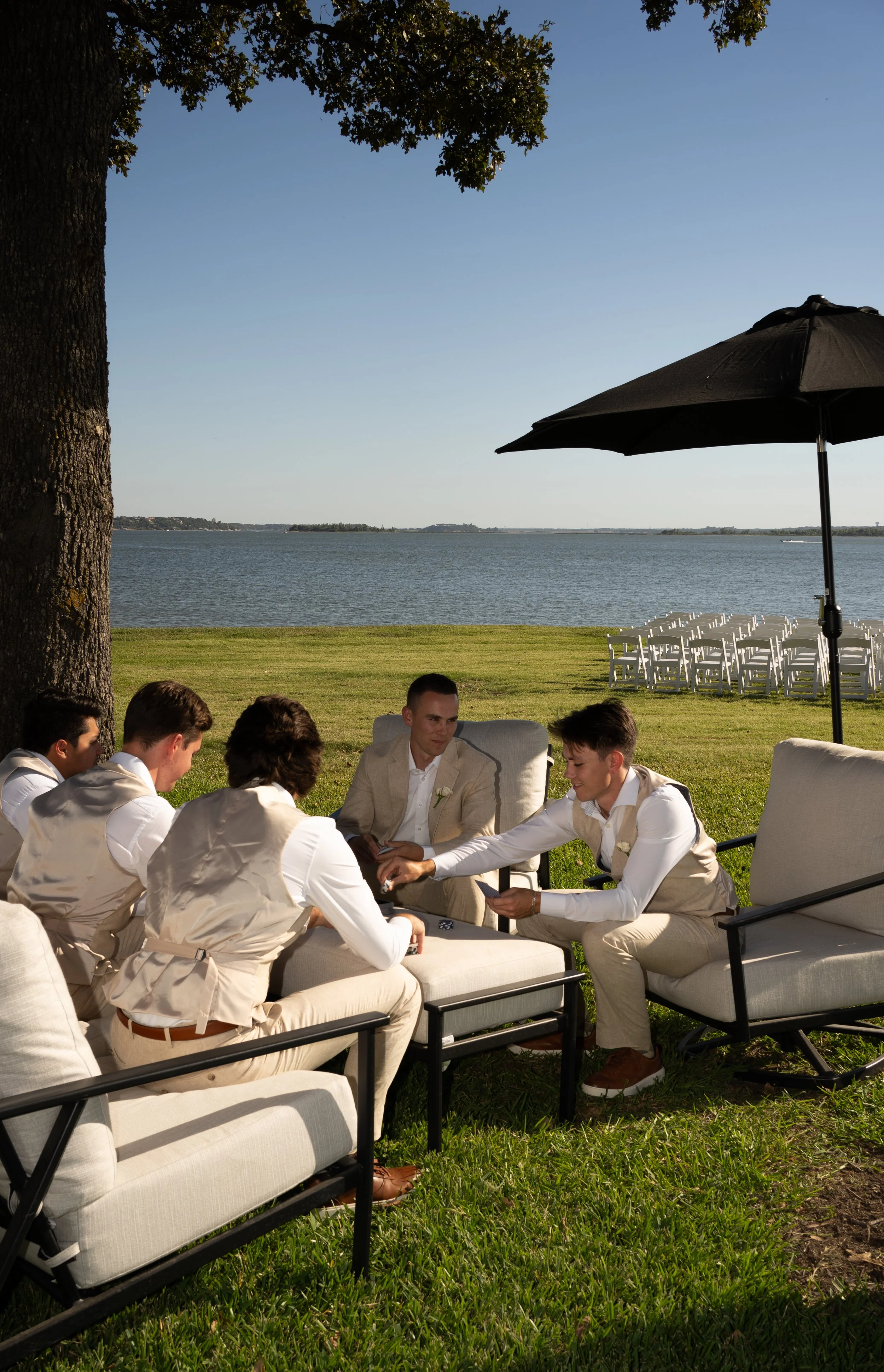 Groom and groomsmen playing poker on the lawn on the morning of the wedding at a bakehouse in Fort Worth, Texas.