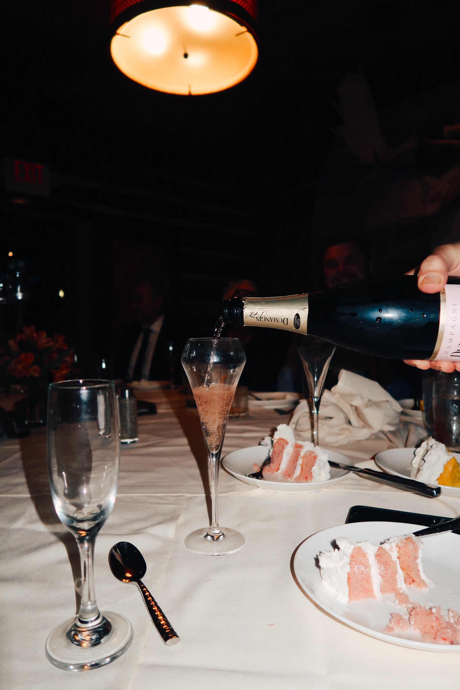 A refined reception detail in Houston, TX, as champagne is poured, capturing the celebratory atmosphere through an editorial lens.