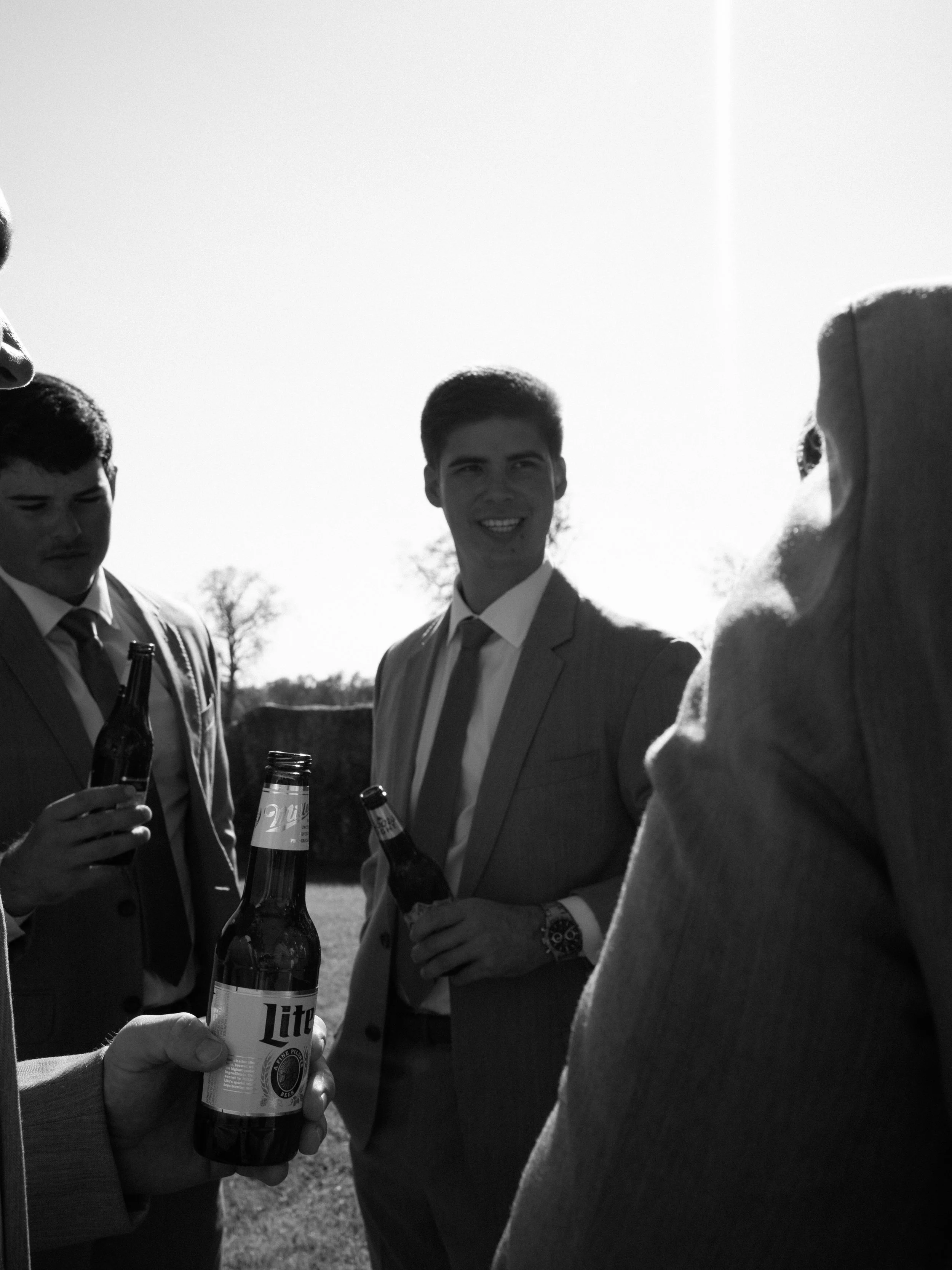 A candid black-and-white moment between the groom and his groomsmen in Montgomery, Texas, documenting genuine connection and anticipation before the ceremony.