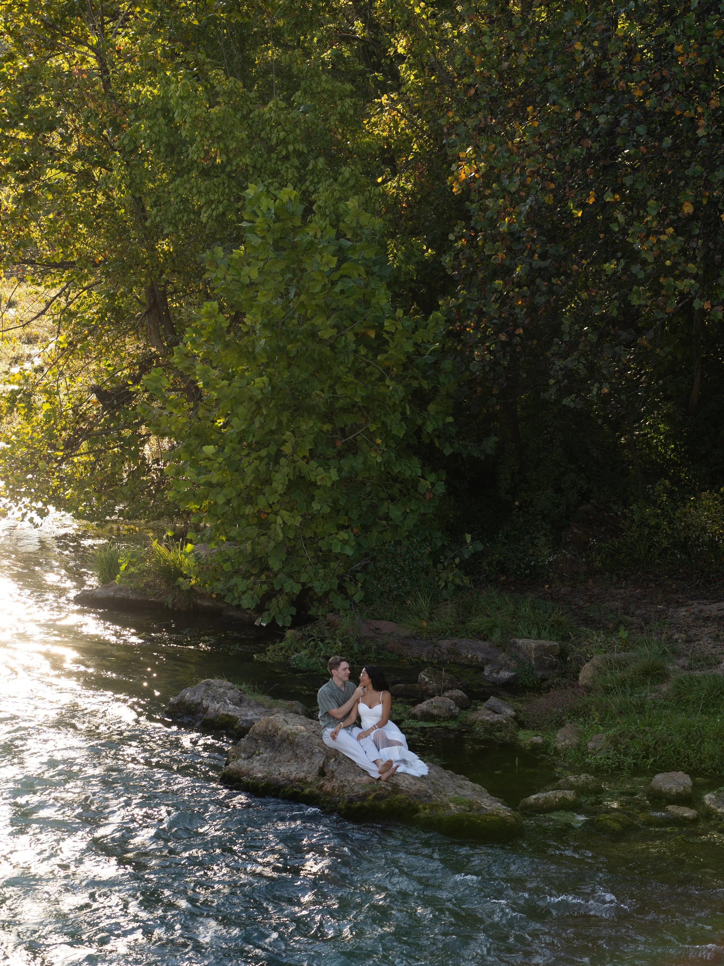 A scenic portrait in Mammoth Spring, Arkansas, where soft sunlight filters through trees along the water’s edge.