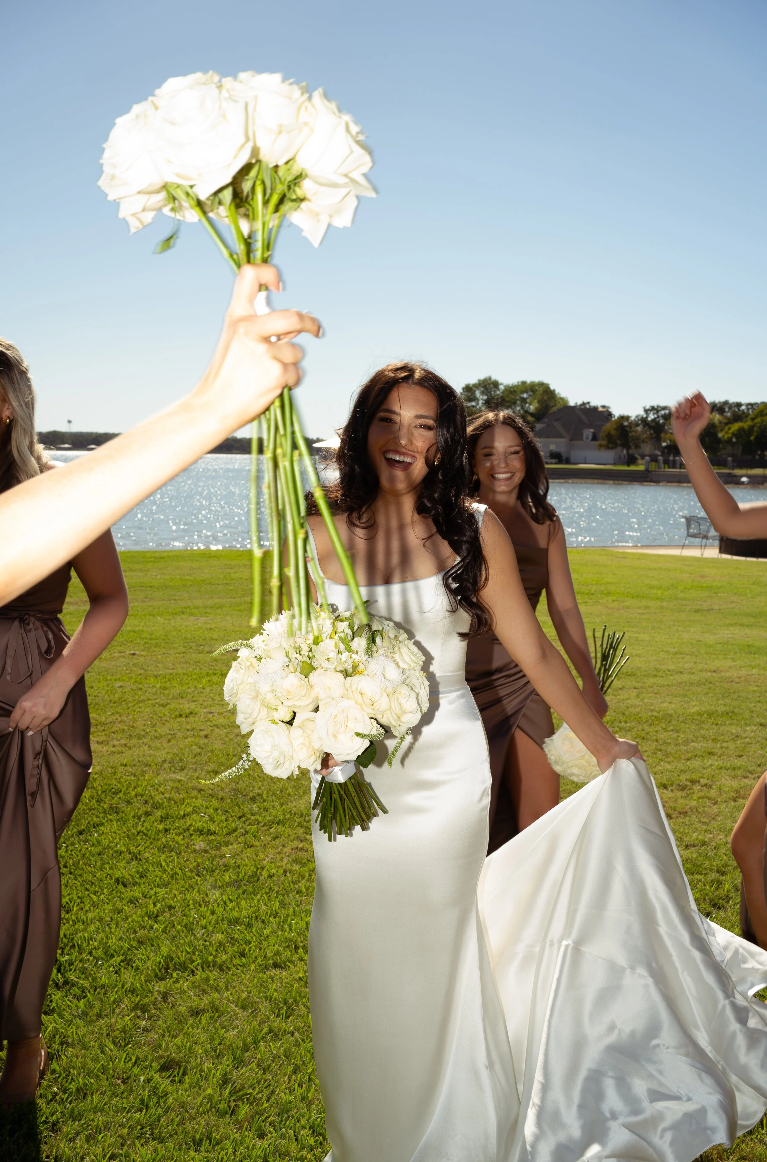 Bride and bridesmaids celebrating with bouquets outdoors at a backyard tent wedding in Fort Worth, Texas.