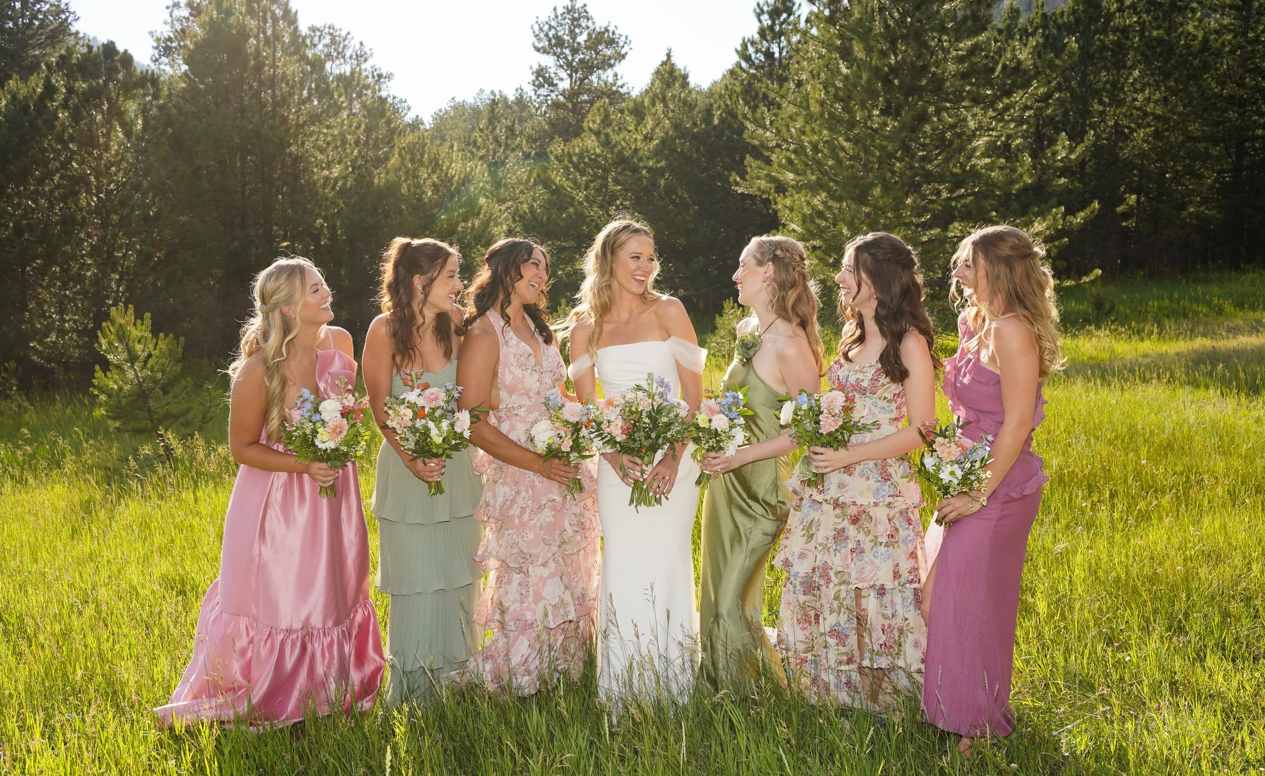 Bridal party laughing in grassy field in Pine, Colorado