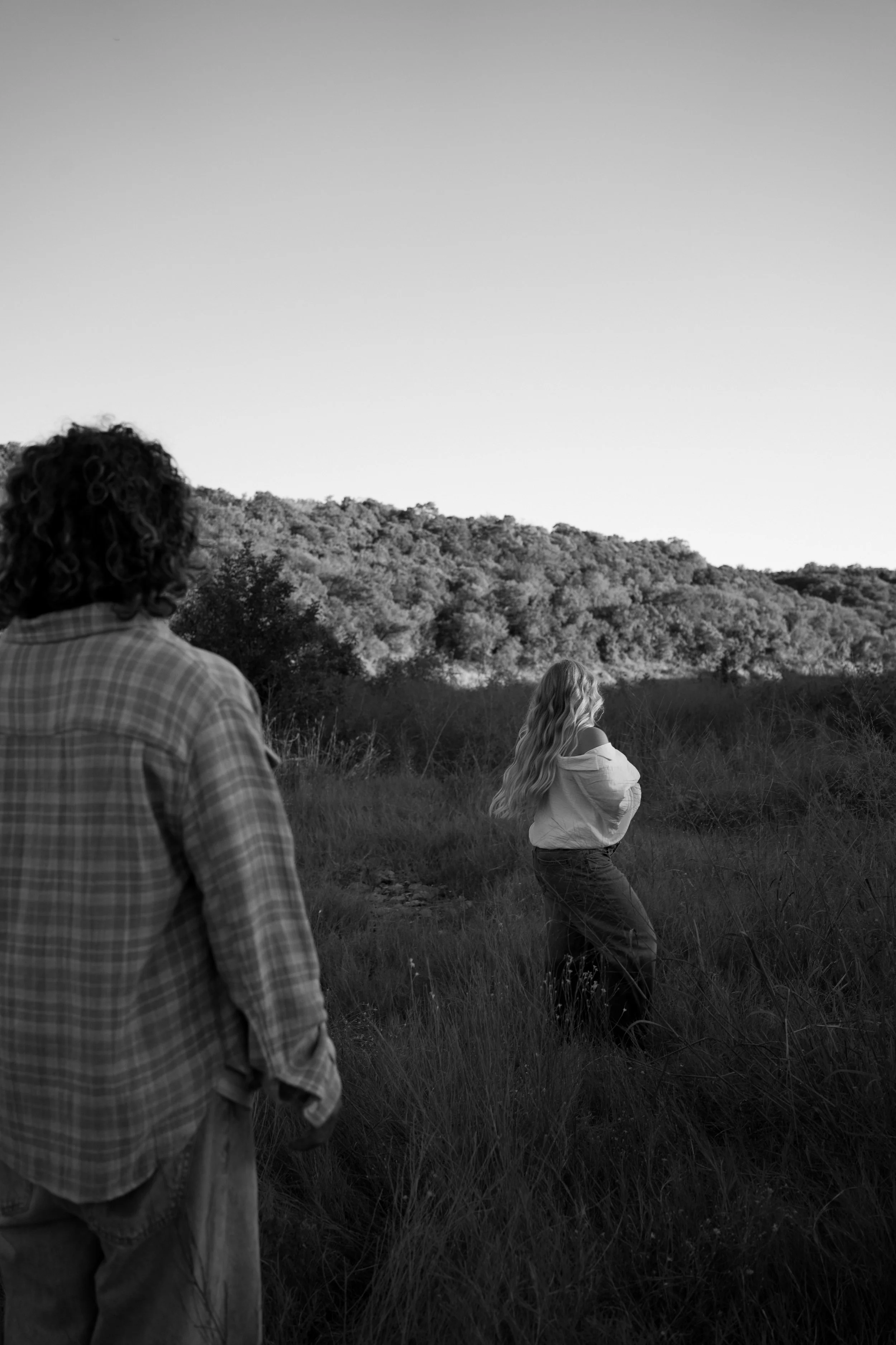 A cinematic black-and-white moment in Rainbow, TX, as the couple moves through the landscape with ease and intention.