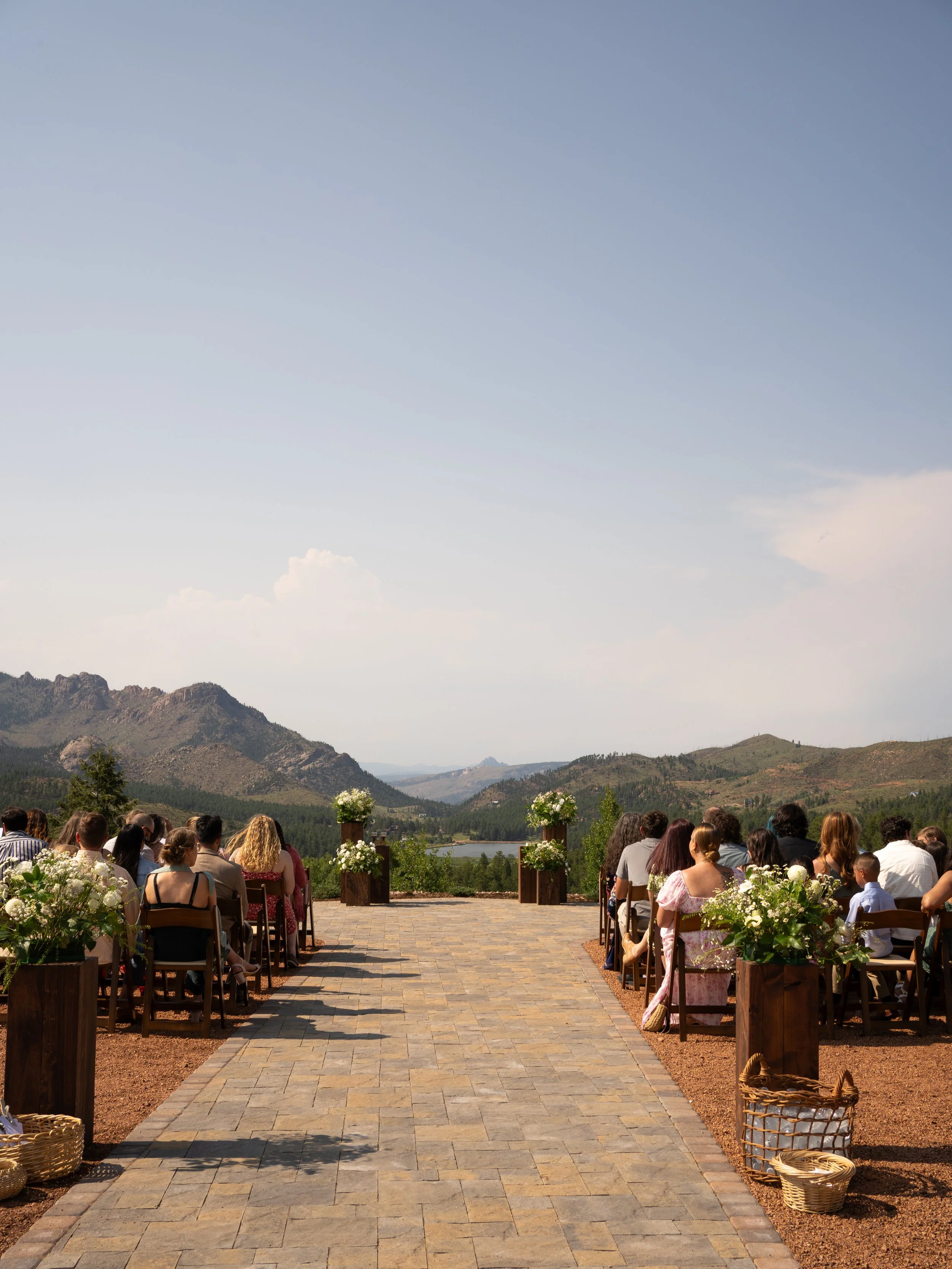 A stunning ceremony scene in Woodland Park, CO, framed by mountain views and open sky.