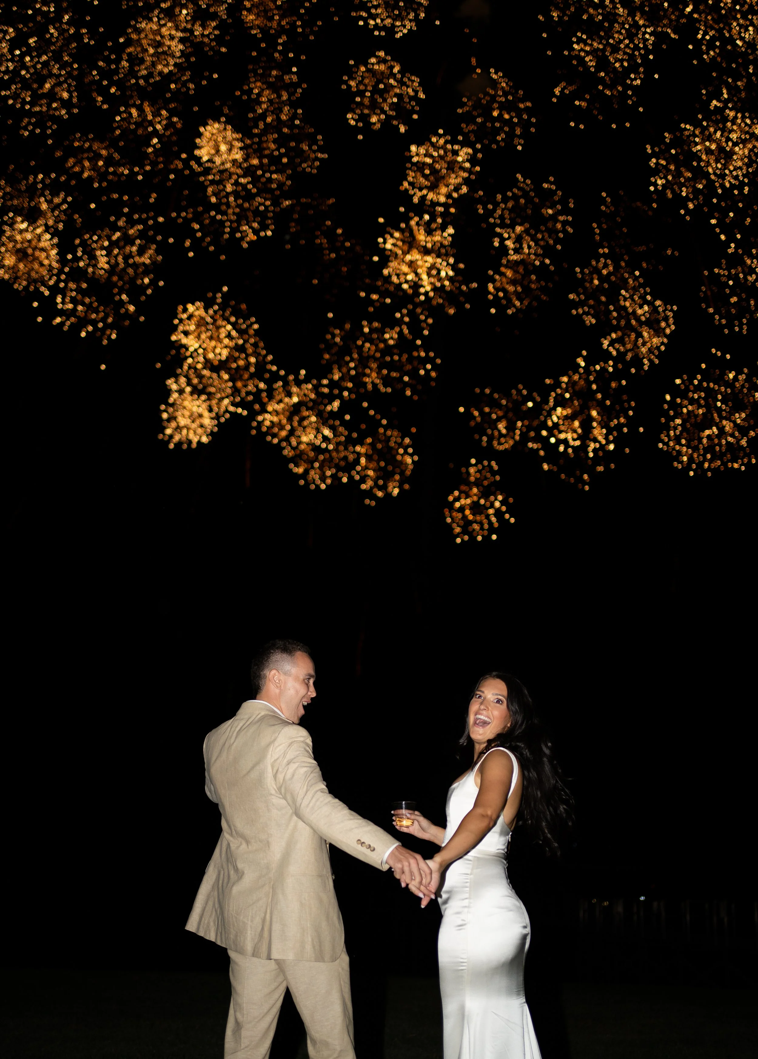 Nighttime couple portrait with direct flash capturing movement and emotion during fireworks send off at a Fort Worth wedding.
